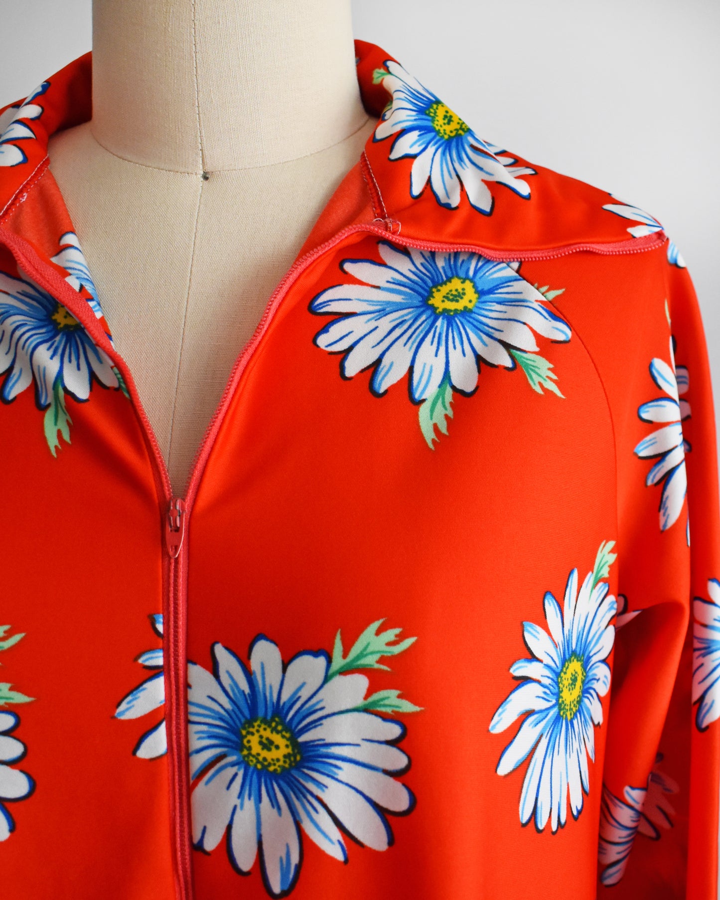 Close up of the collar, floral print, and zipper on the red house dress