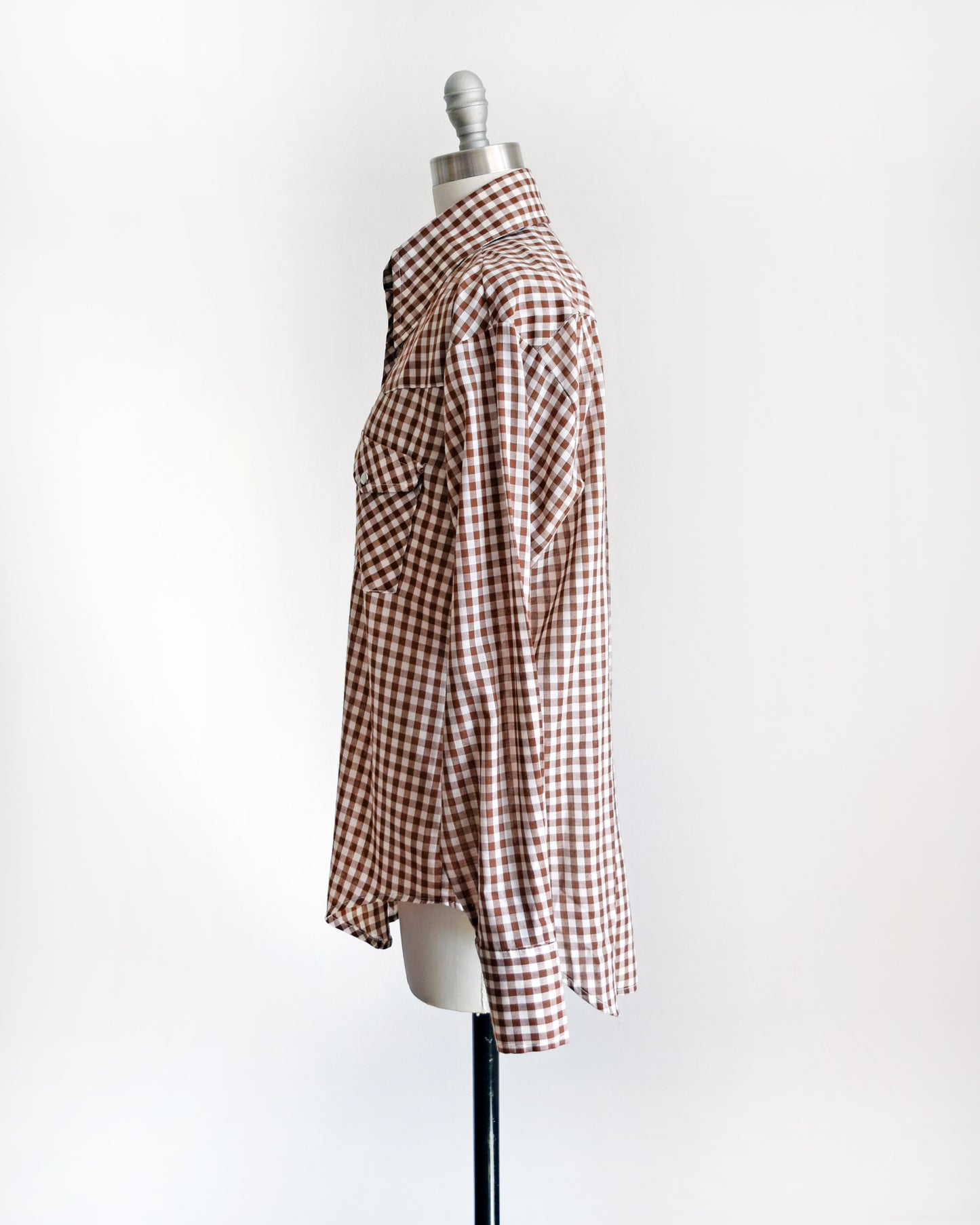 side view of a vintage 1970s brown and white gingham pearl snap shirt