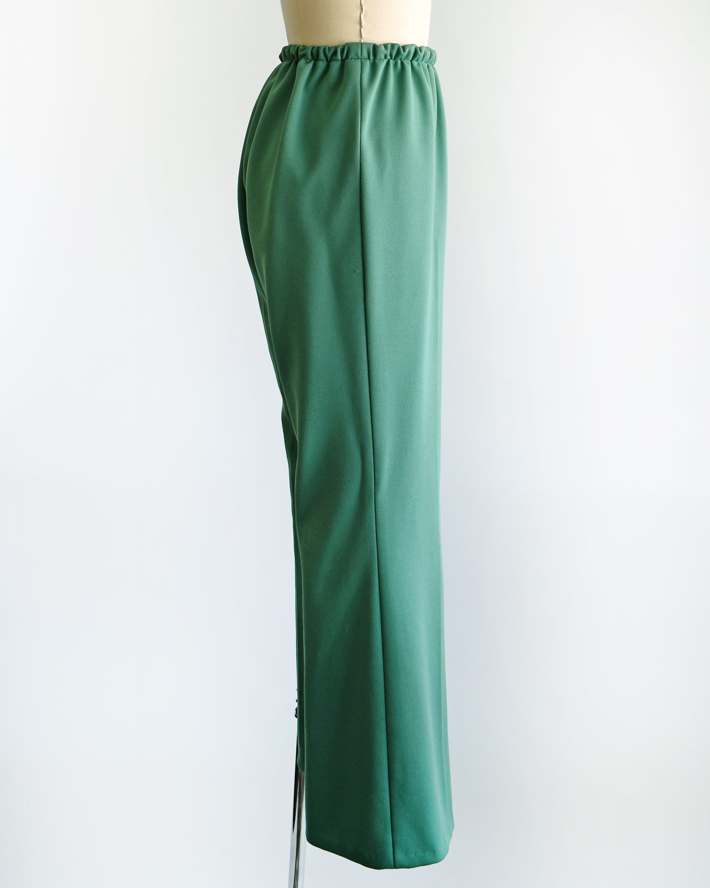 side view pf a pair of vintage 1970s green wide leg pants on a dress form