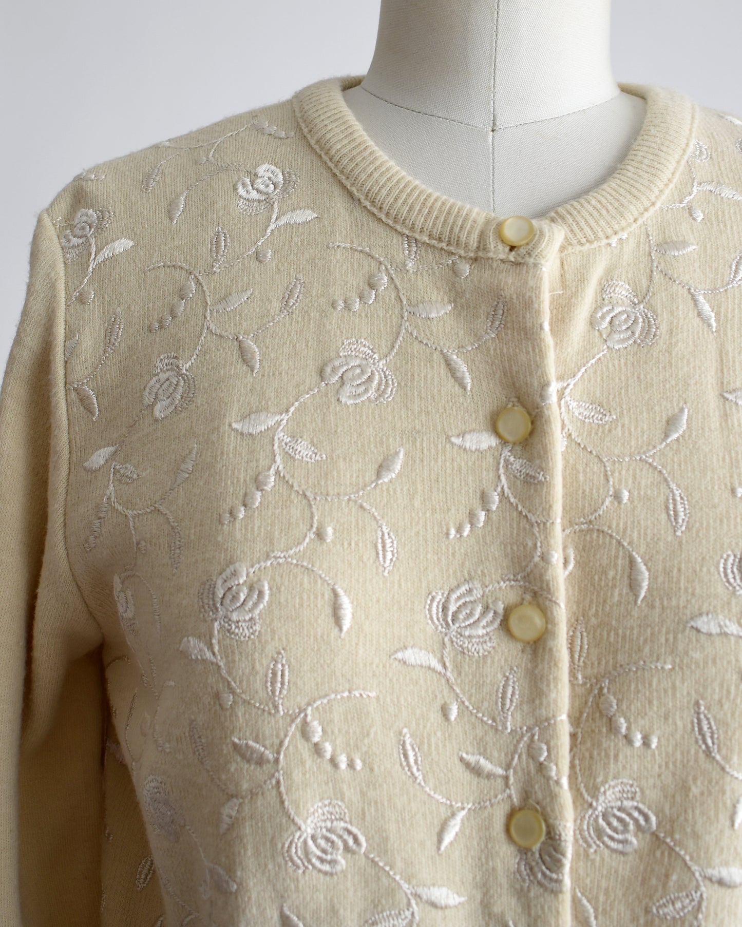 close up of the embroidered flowers and buttons on the front of the cardigan