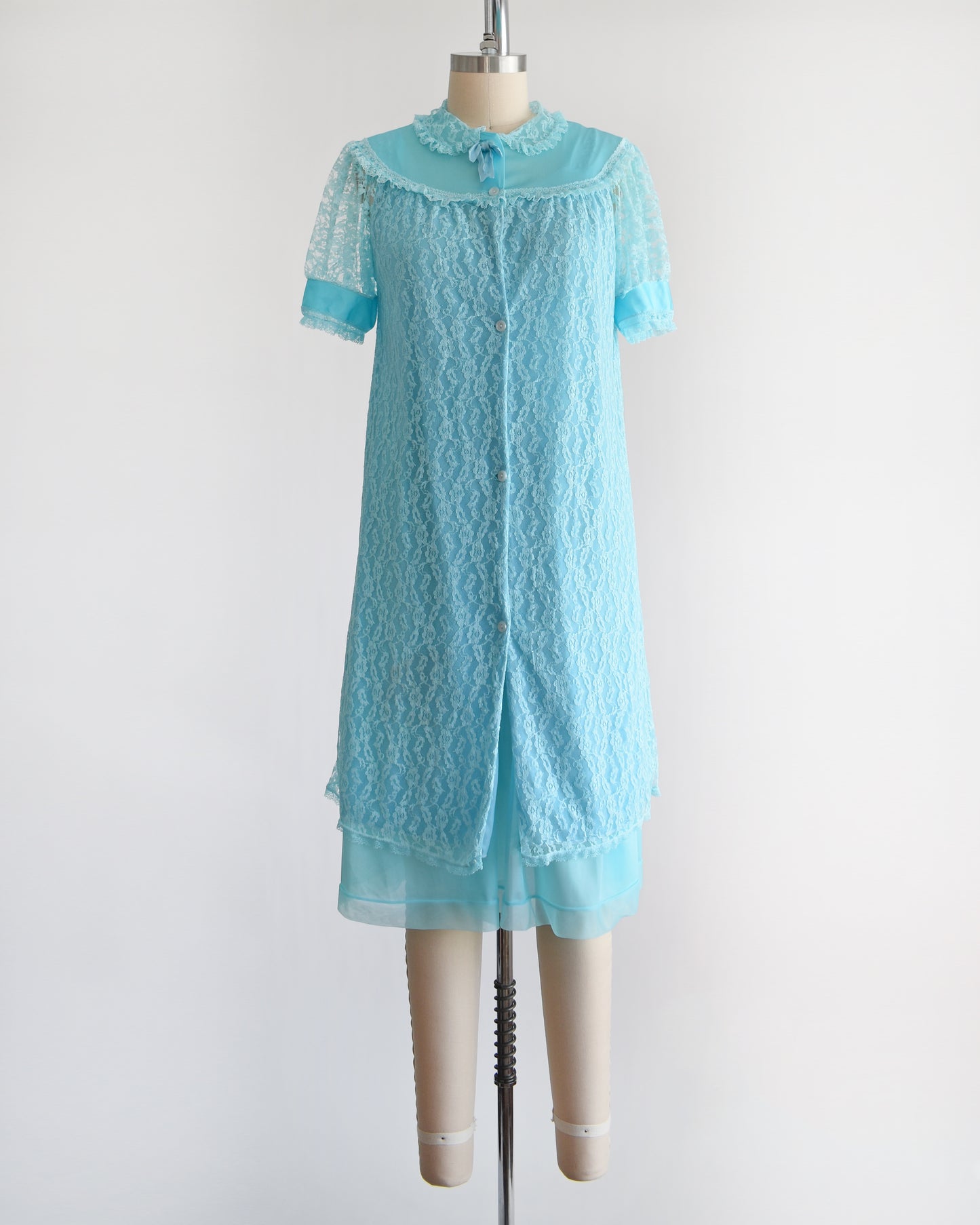 A vintage 1960s aqua blue peignoir set that comes with a lace robe and matching nightgown. The robe is buttoned in this photo.