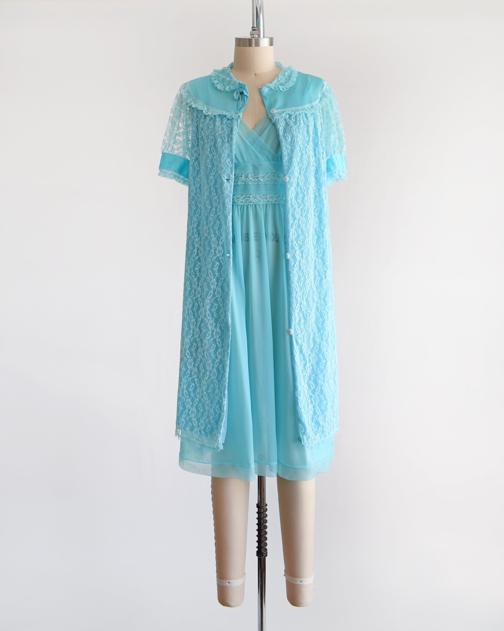 A vintage 1960s aqua blue peignoir set that comes with a lace robe and matching nightgown. The robe is unbuttoned in this photo.