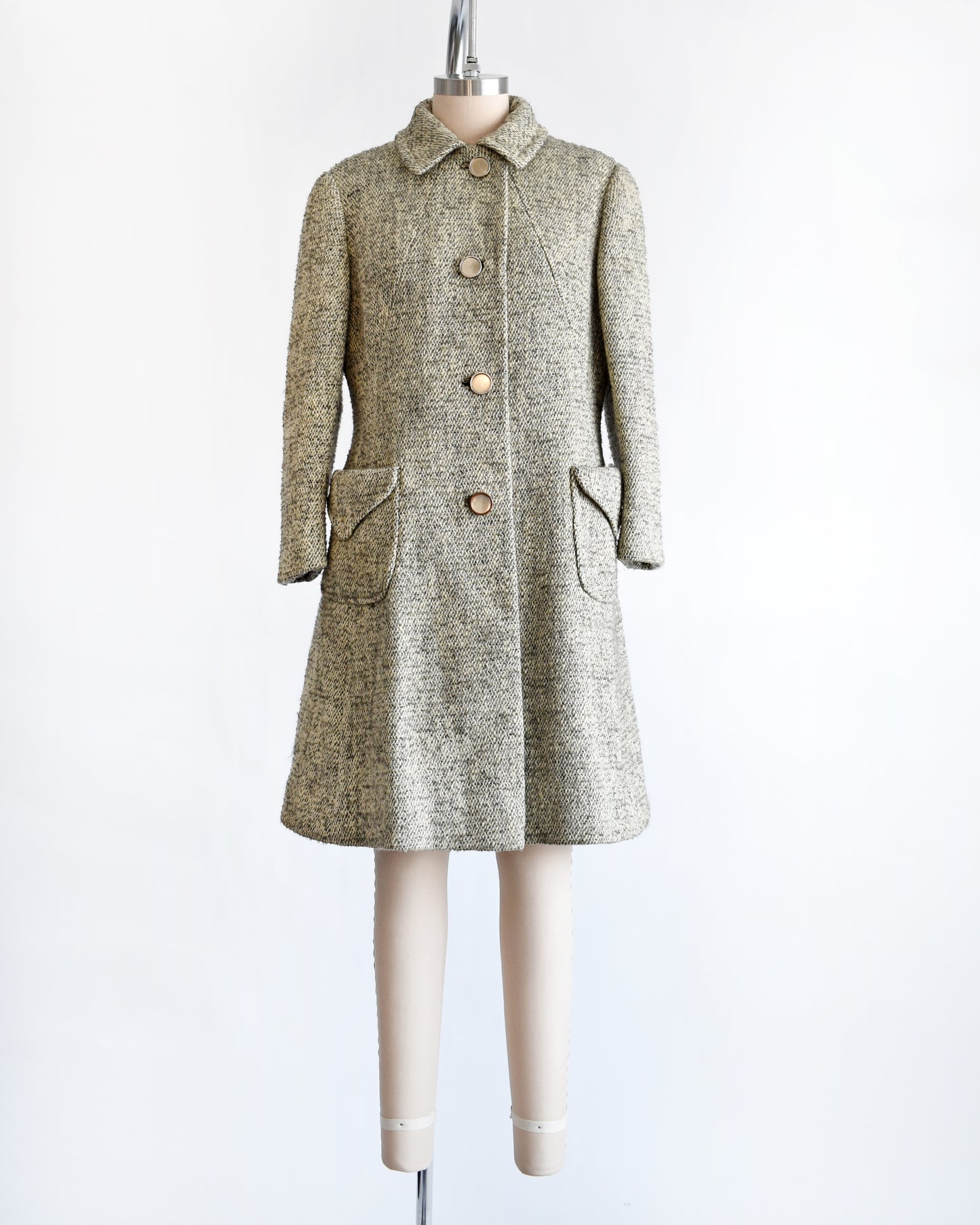 a vintage 1960s gray and cream wool bouclé coat. the buttons are buttoned all the way up.
