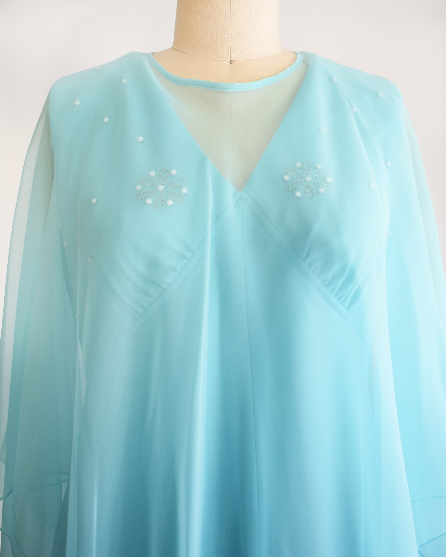 Close up of the bodice with the cape overlay.