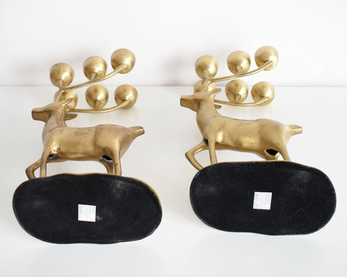 A view of the two deer laying down on their side, showing the bottom of the base and the cutouts along the underside