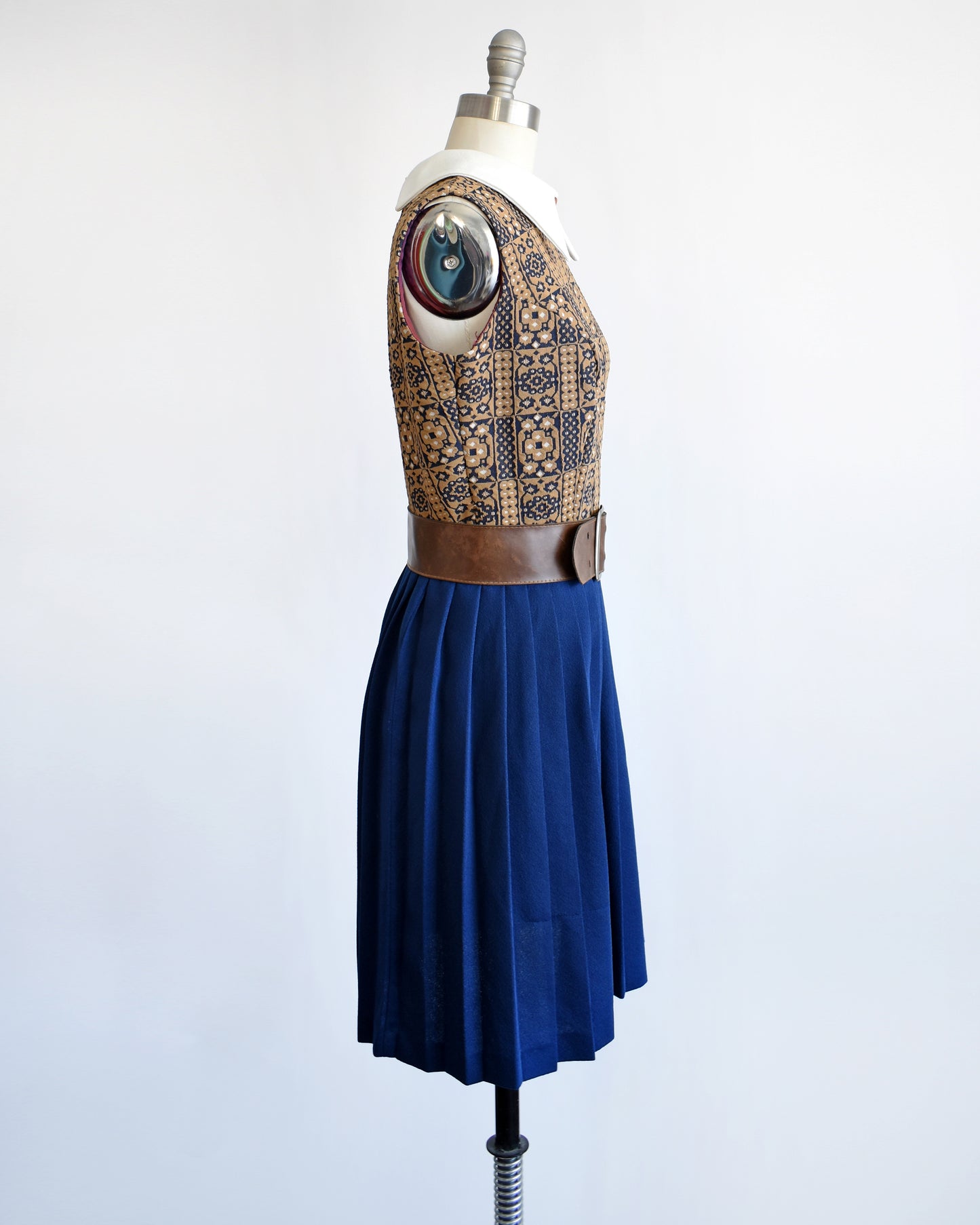 Side view of a vintage 1960s brown, blue, and white mod scooter dress with brown belt