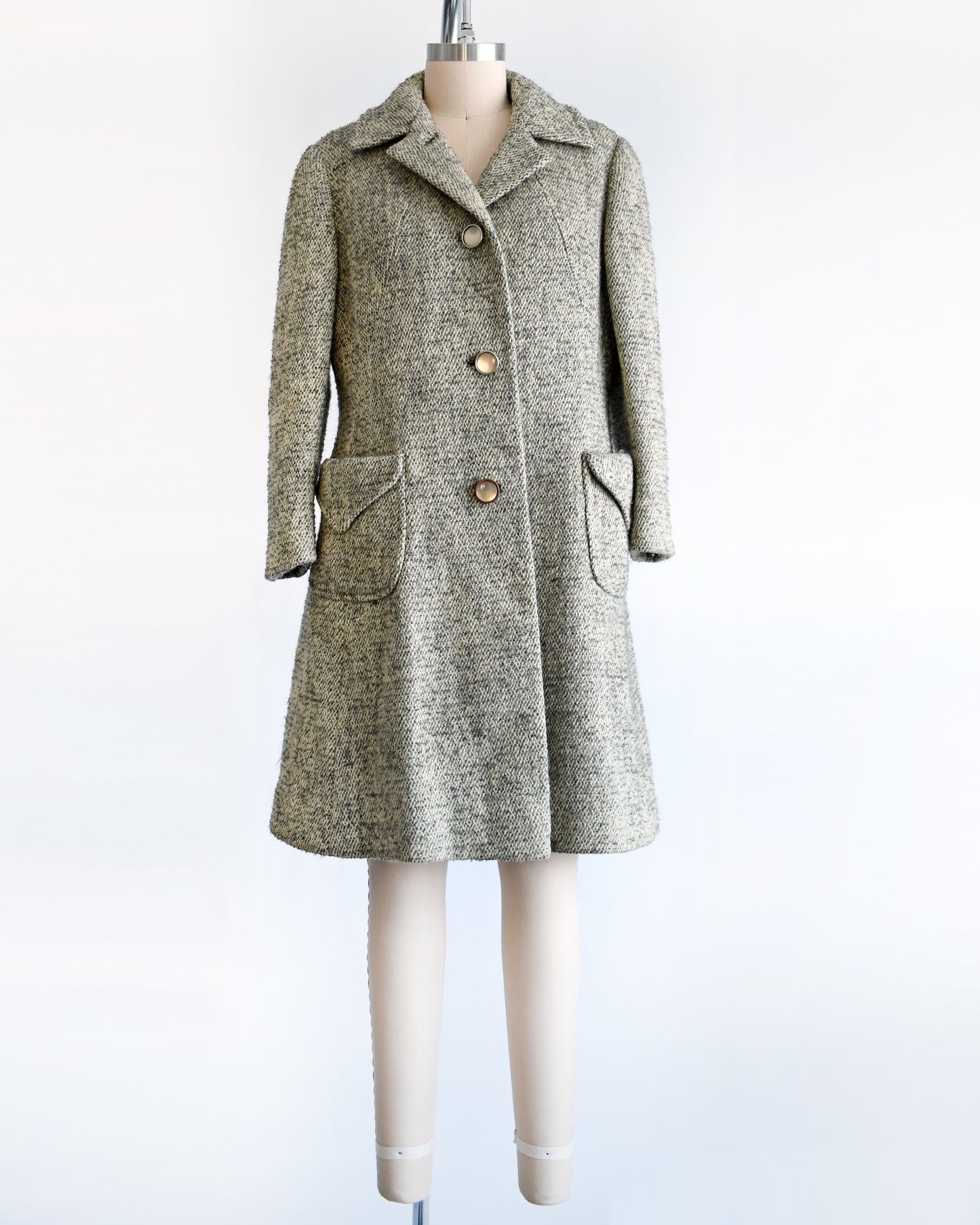 a vintage 1960s gray and cream wool bouclé coat. the top button is unbuttoned