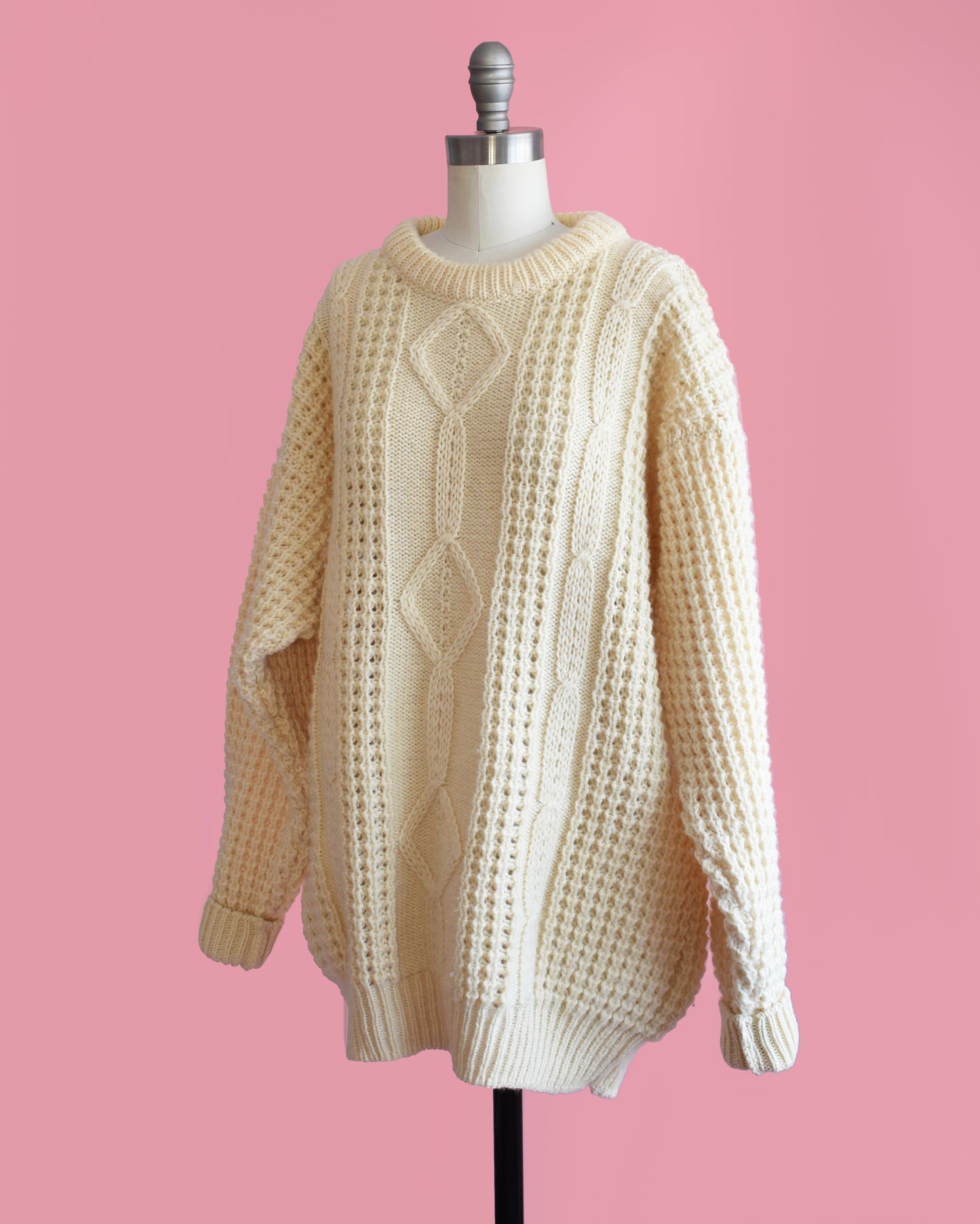 side front view of a vintage Irish cream wool with classic cable knit detail.