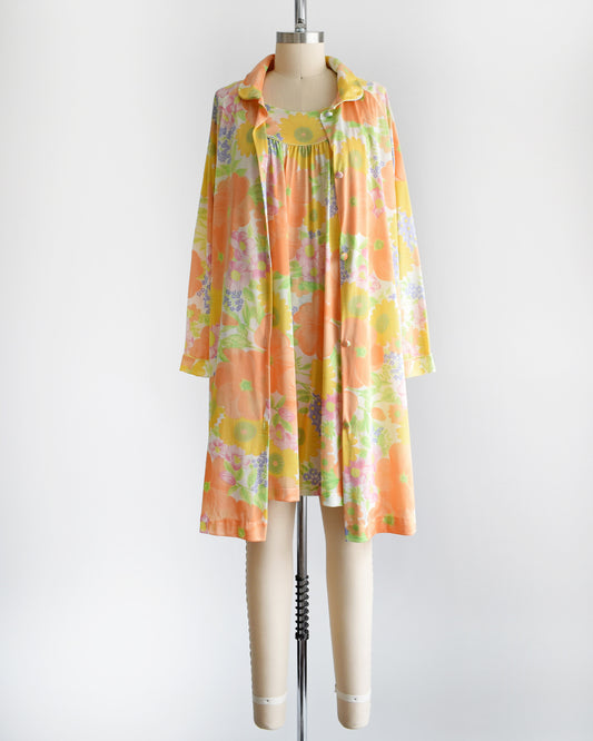 Cute vintage 1970s floral peignoir set by Lorraine. This set includes a nightgown and matching button up long sleeve robe that is white and has an orange, yellow, pink, purple, and green floral print. 