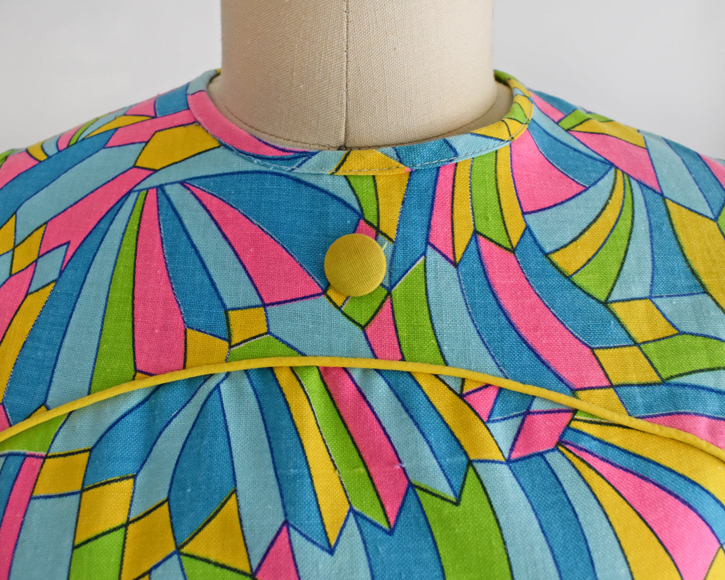 close up of the bodice of the dress, which shows the button and the yellow trim