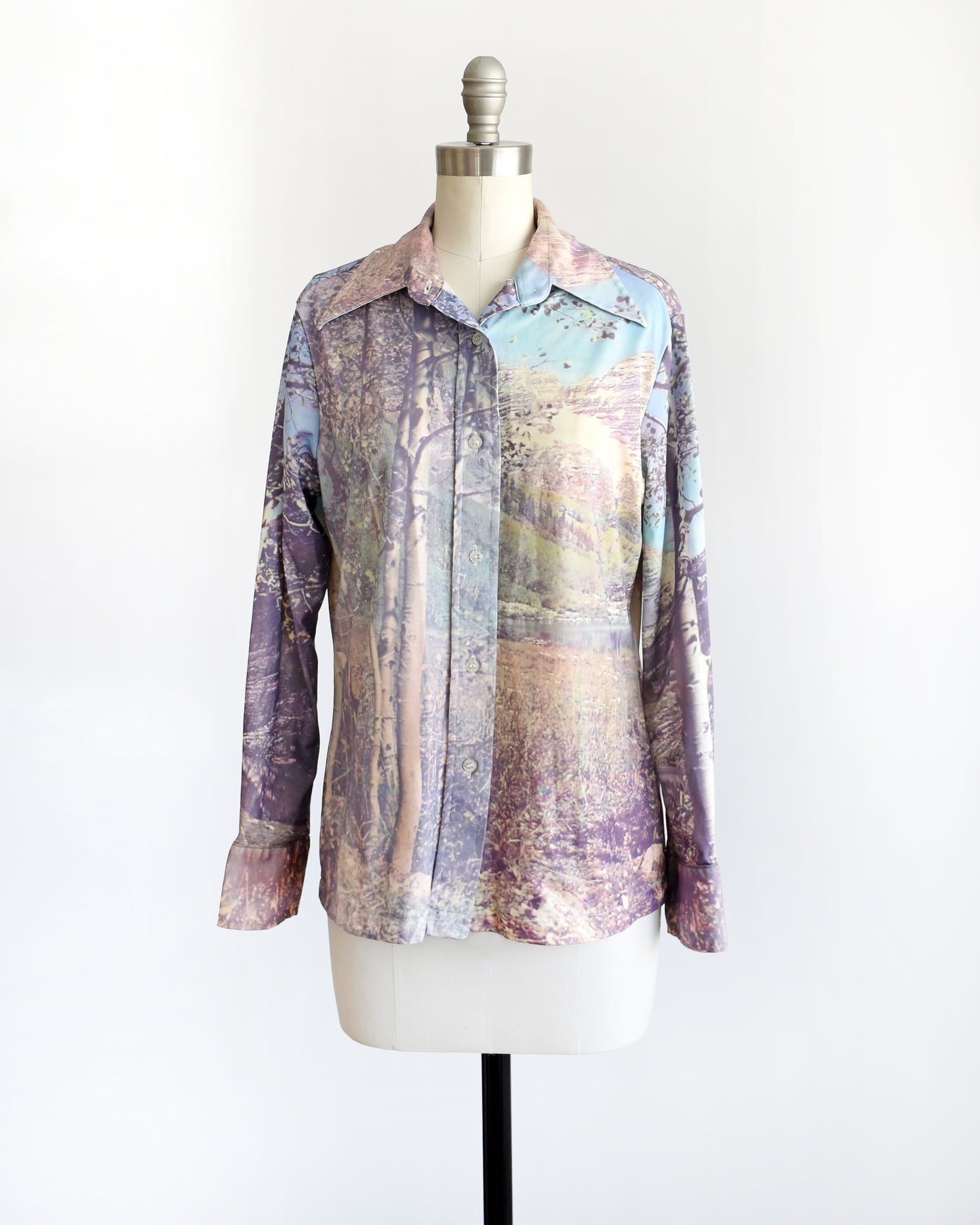 side front view of a vintage 1970s mountain scene disco blouse. the top button is unbuttoned in this photo