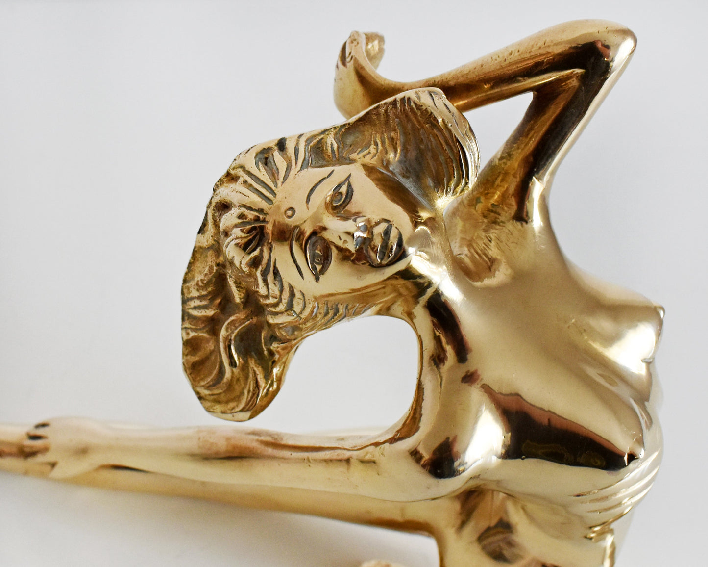 close up of the face of the brass nude woman