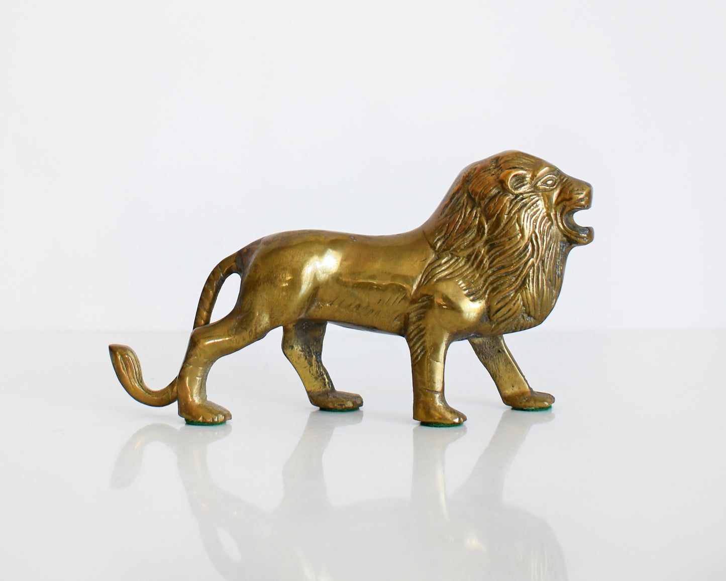 side view of a brass lion figurine 