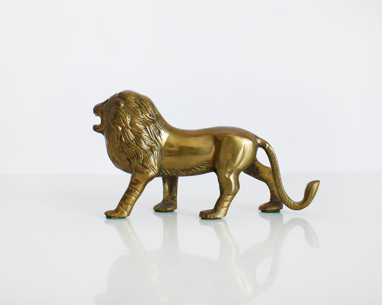 side view of a brass lion figurine 