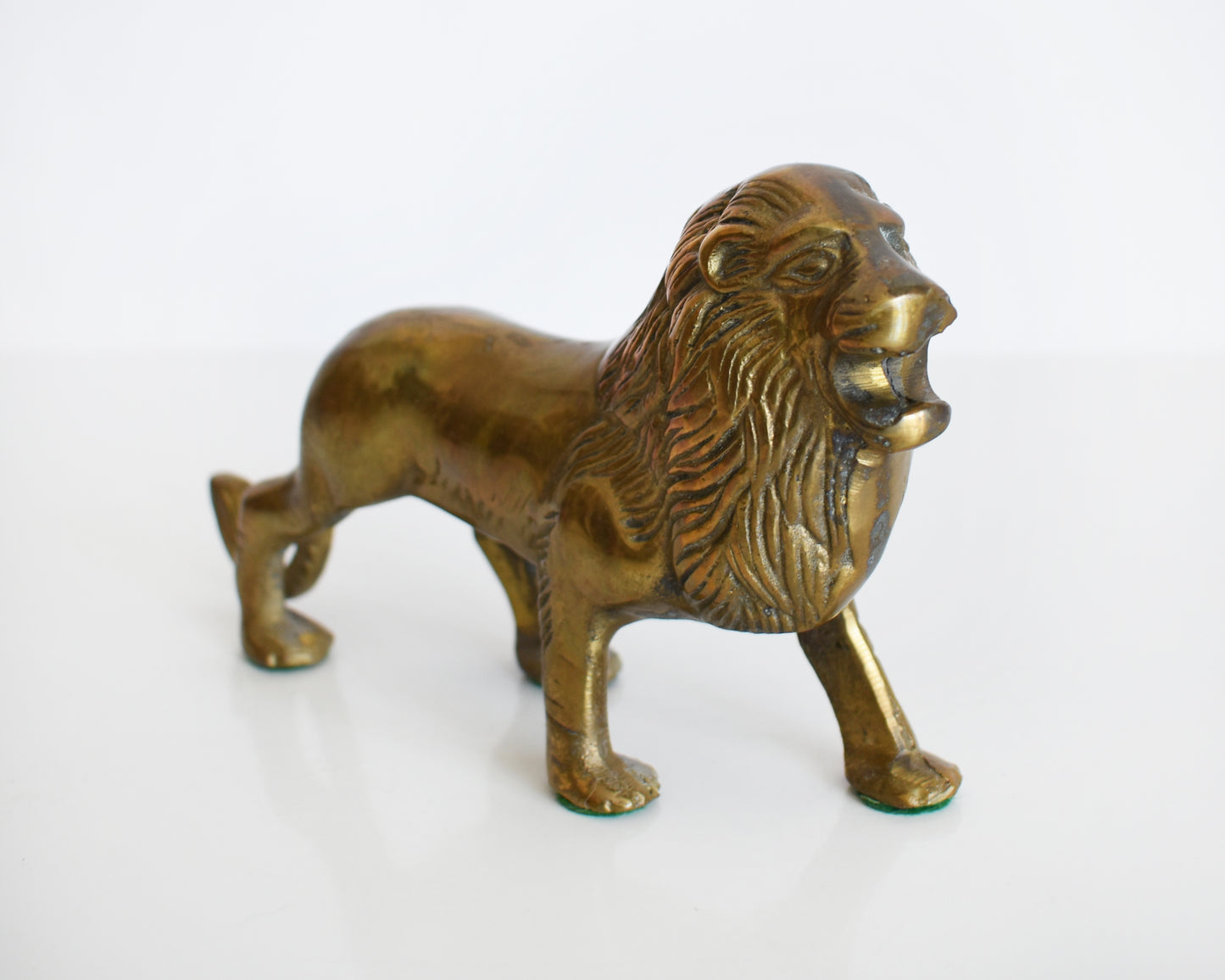 side front view of a brass lion figurine 