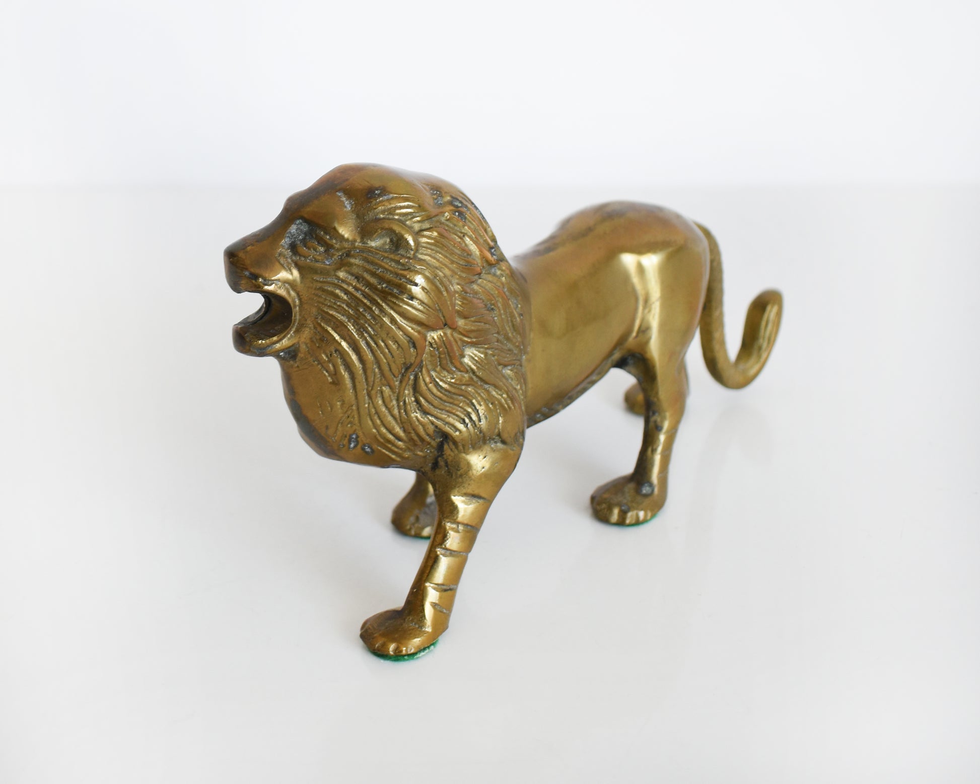 side front view of a brass lion figurine 