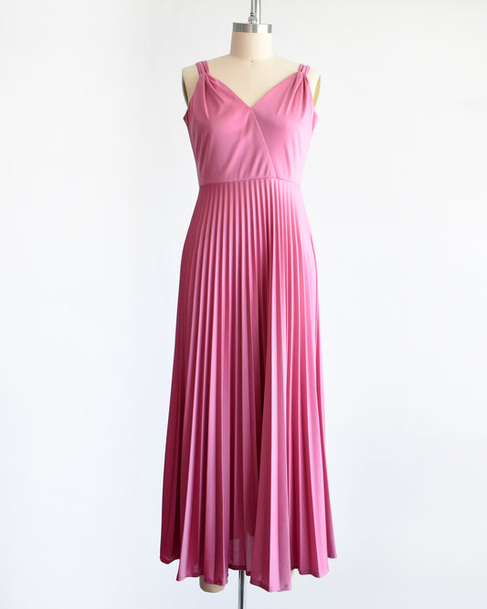 a vintage 1970s dusty pink disco maxi dress that has a faux wrap front, and a long accordion pleated maxi skirt.