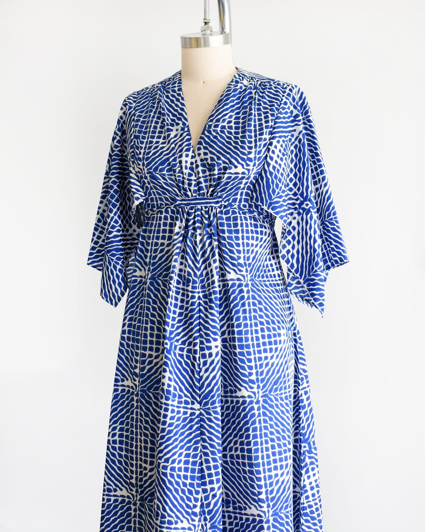 side front view of a vintage 1970s blue and white caftan with handkerchief sleeves