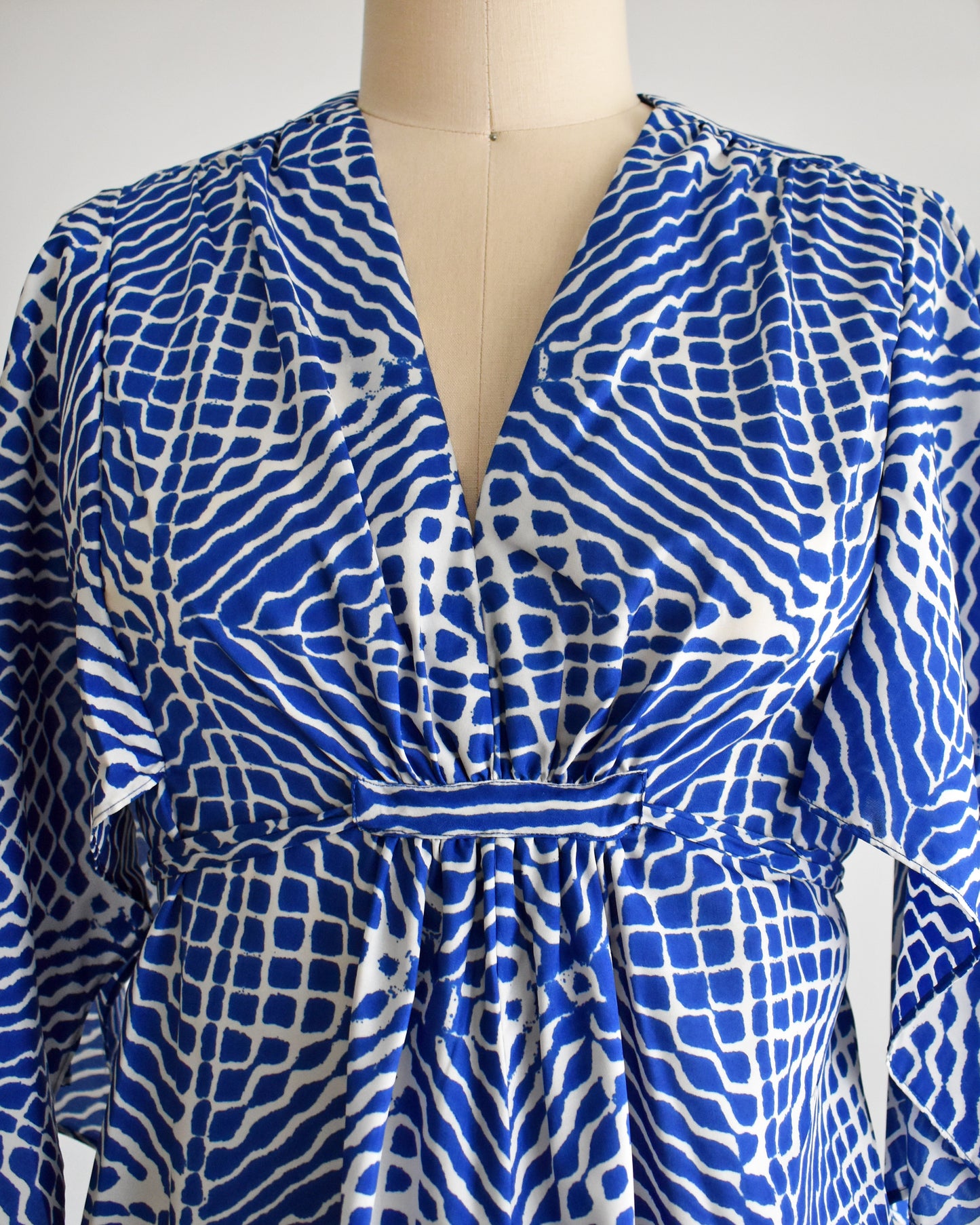 close up of the bodice of a vintage 1970s blue and white caftan with handkerchief sleeves
