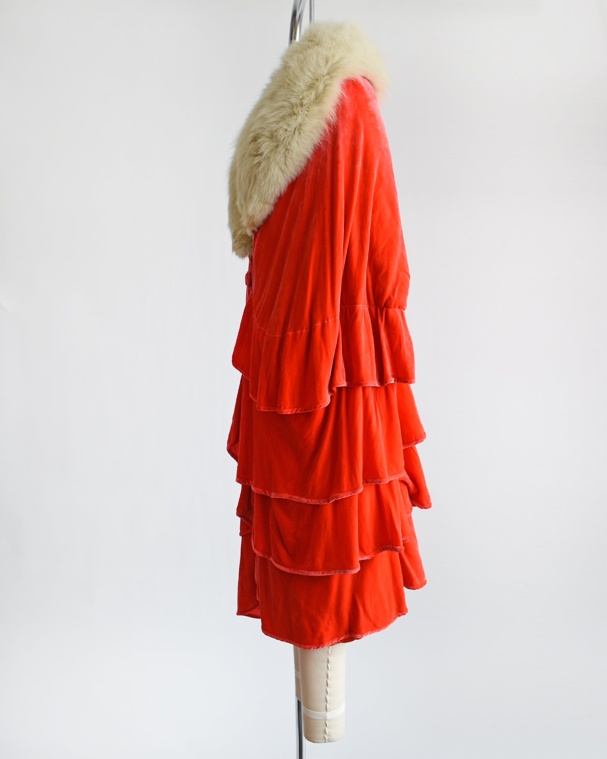 Side view of a vintage 1920s ruffled silk velvet opera coat with cream fox fur trim