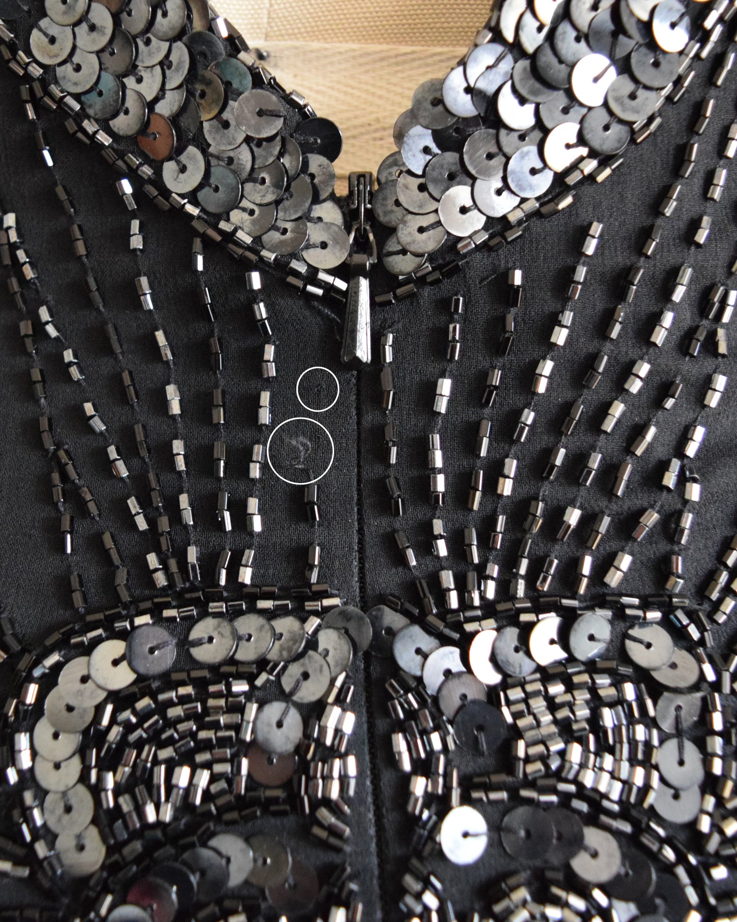 A photo which shows a few beads missing near the zippe