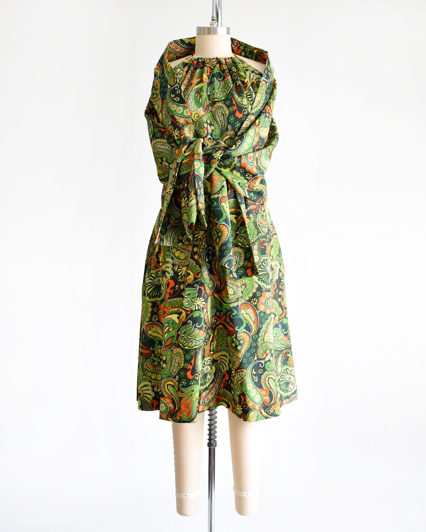 A vintage 1970s psychedelic paisley dress with matching shawl on a mannequin against a white background
