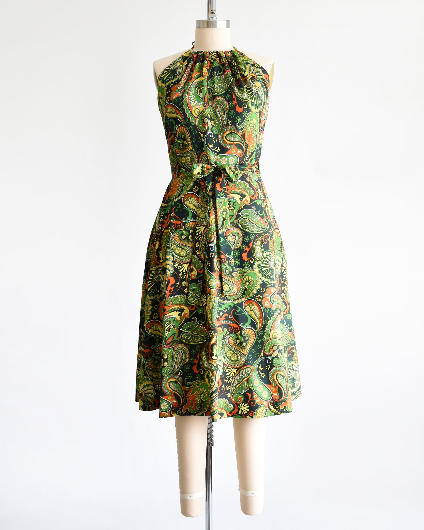 A vintage 1970s psychedelic paisley dress on a mannequin against a white background