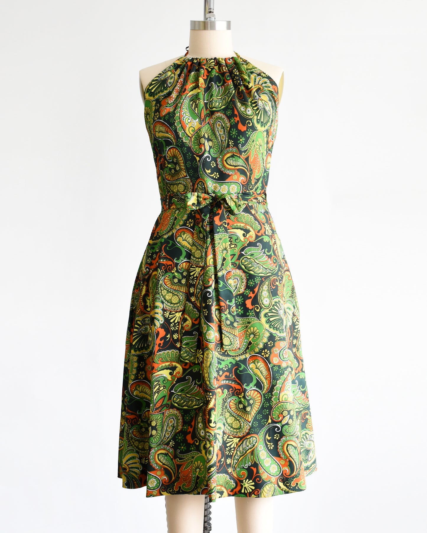 A vintage 1970s psychedelic paisley dress on a mannequin against a white background