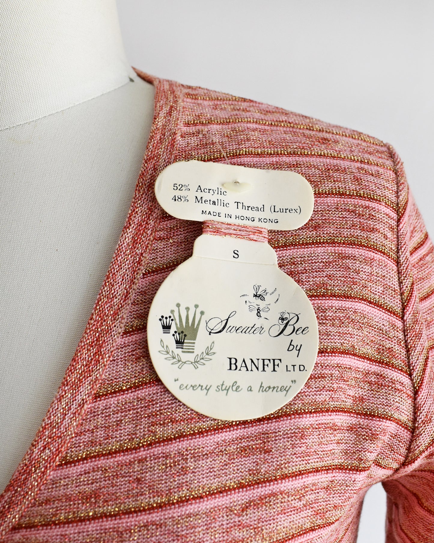 close up of a label on a mannequin, featuring 'Sweater Bee by Banff'.