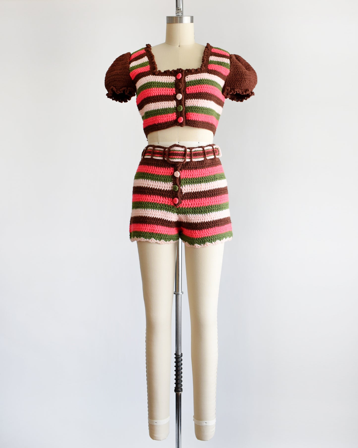 a vintage 1970s striped knit crop top and hot pant shorts on a mannequin against a white background