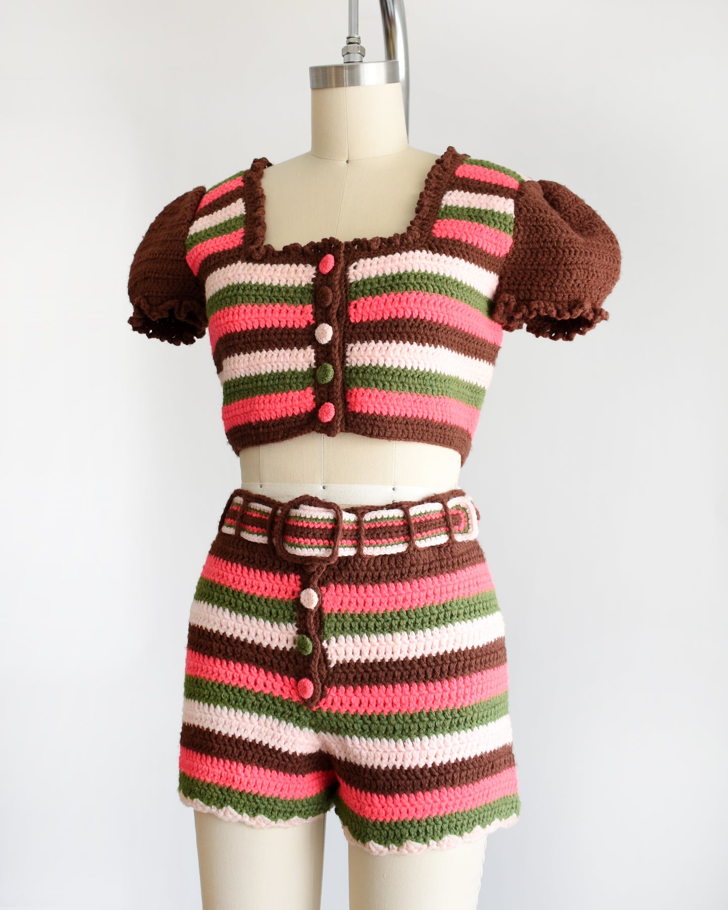 side front view of a vintage 1970s striped knit crop top and hot pant shorts on a mannequin against a white background