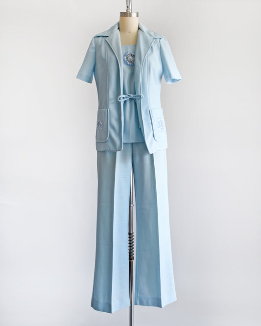 Classic vintage 1970s three piece light blue pantsuit. This set comes with a matching short sleeve blazer, a tank top, and wide leg pants.