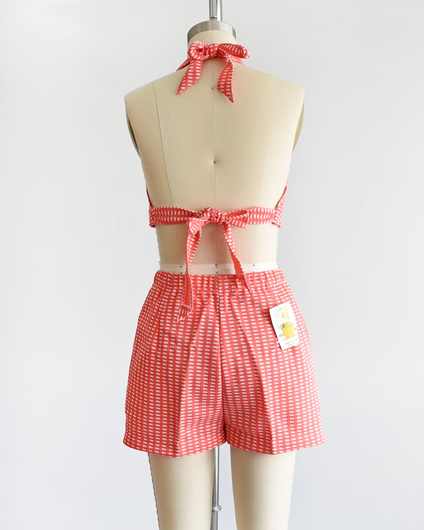 back view of a vintage 1970s coral pink two piece halter top and short set
