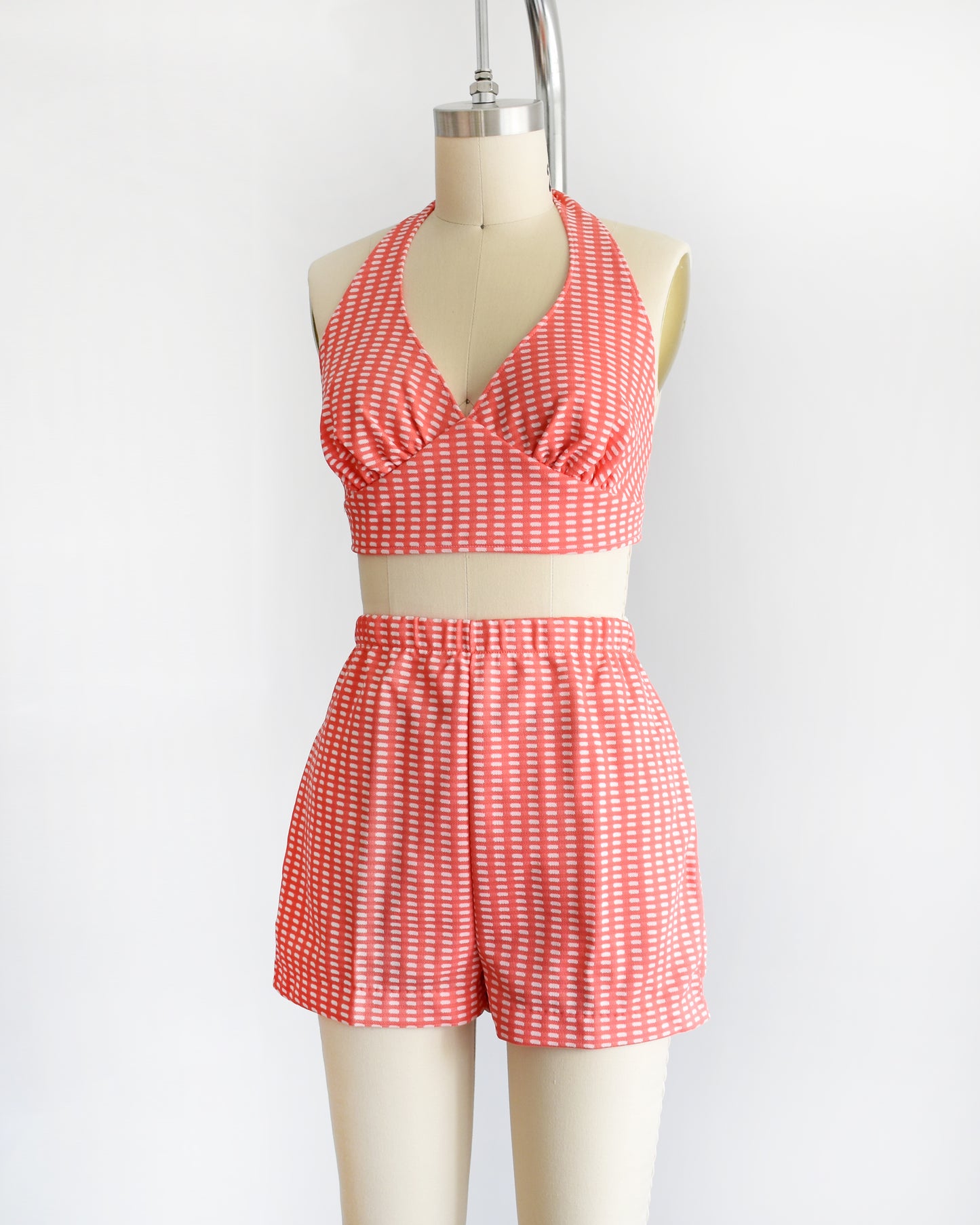 side front view of a vintage 1970s coral pink two piece halter top and short set