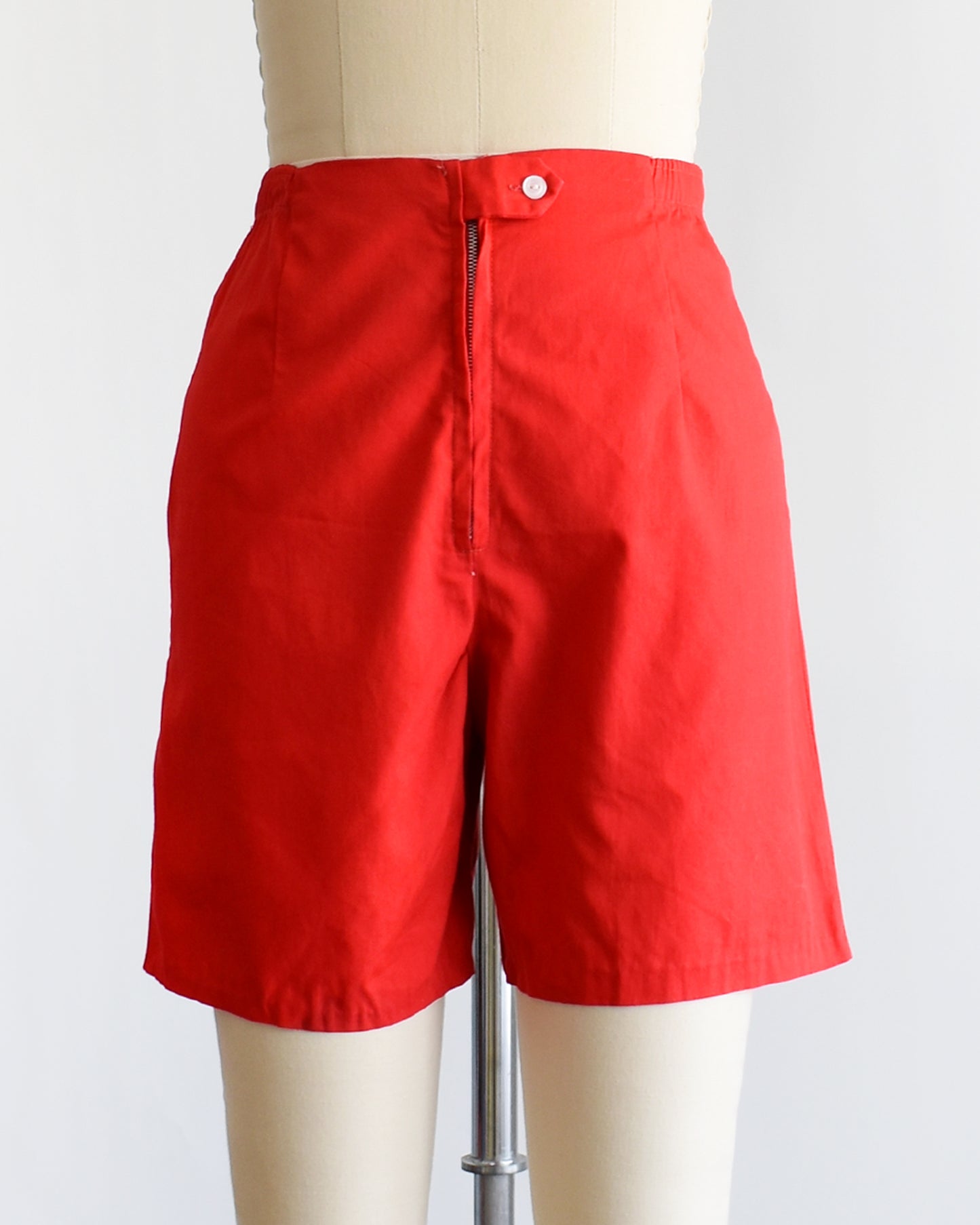 a pair of vintage 1960s red shorts on a mannequin against a white background