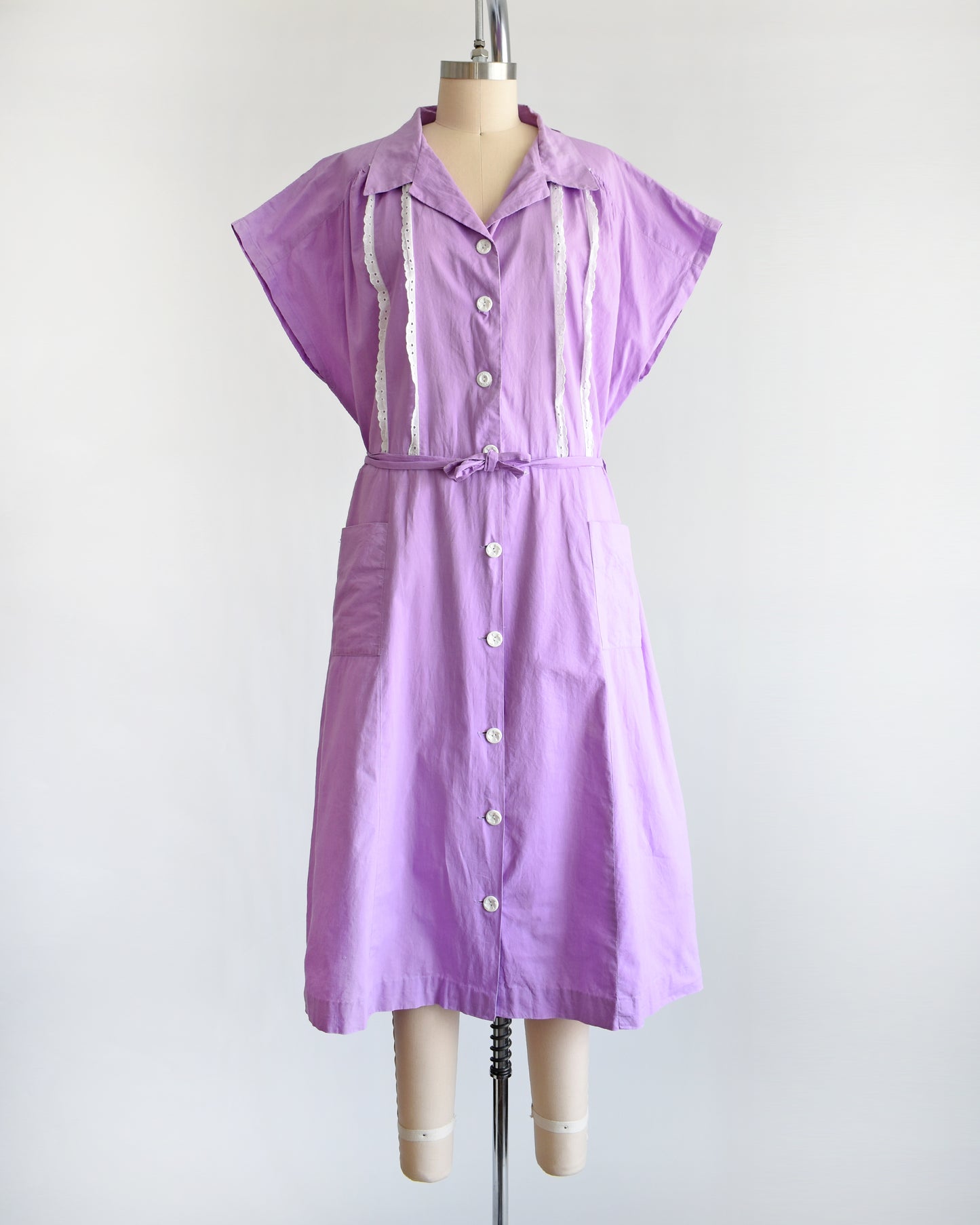 A vintage 1950s purple dress by Fruit of the Loom on a mannequin against a white background