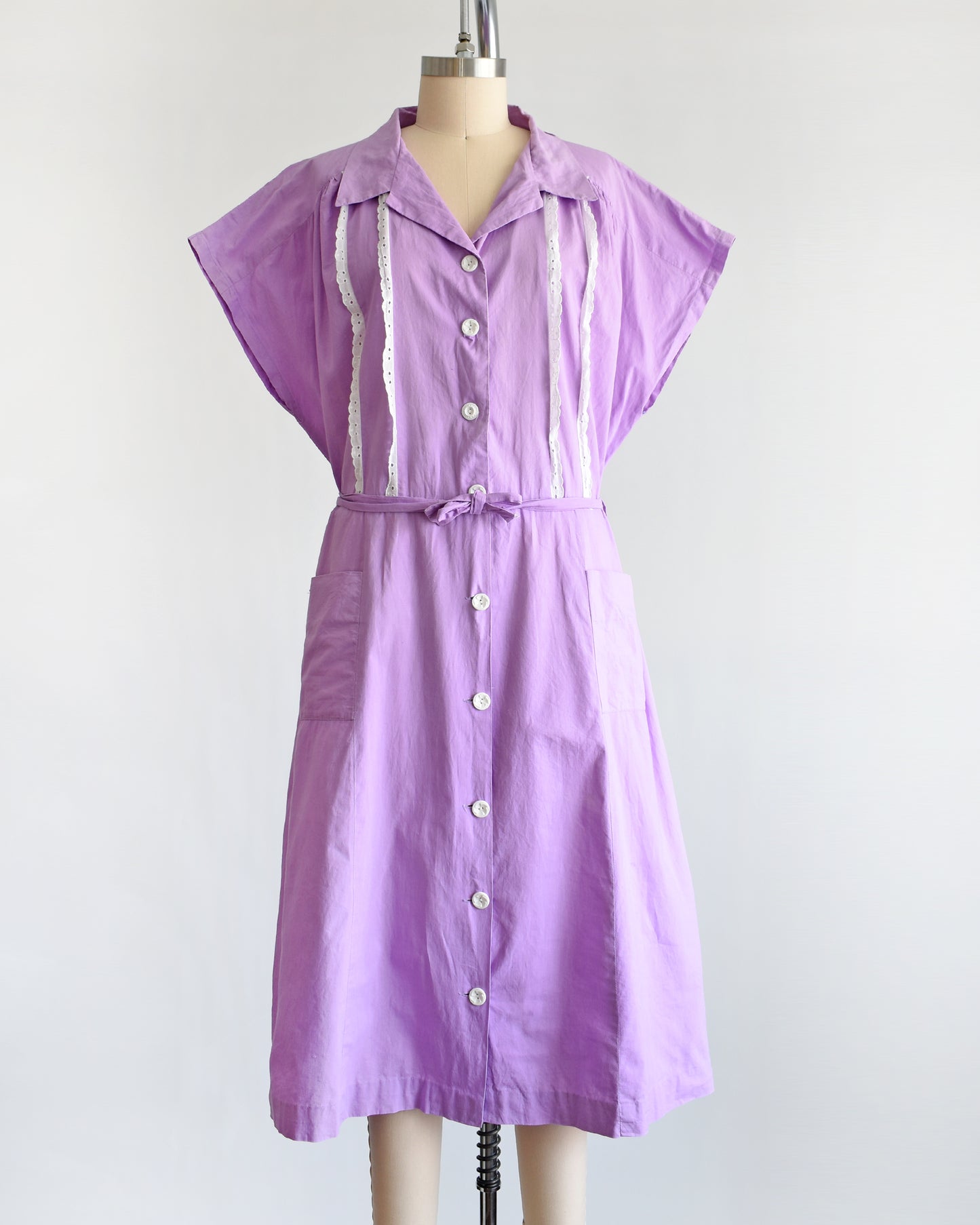 A vintage 1950s purple dress by Fruit of the Loom on a mannequin against a white background