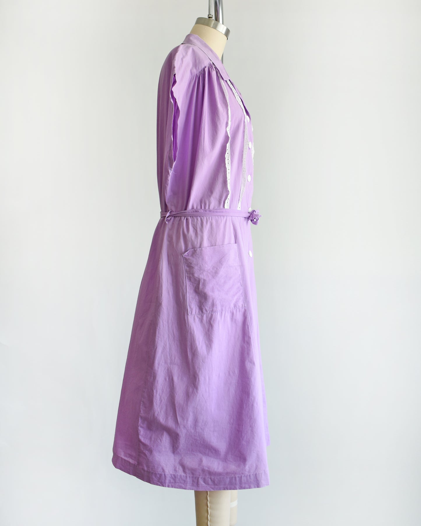 side view of a vintage 1950s purple dress by Fruit of the Loom on a mannequin against a white background