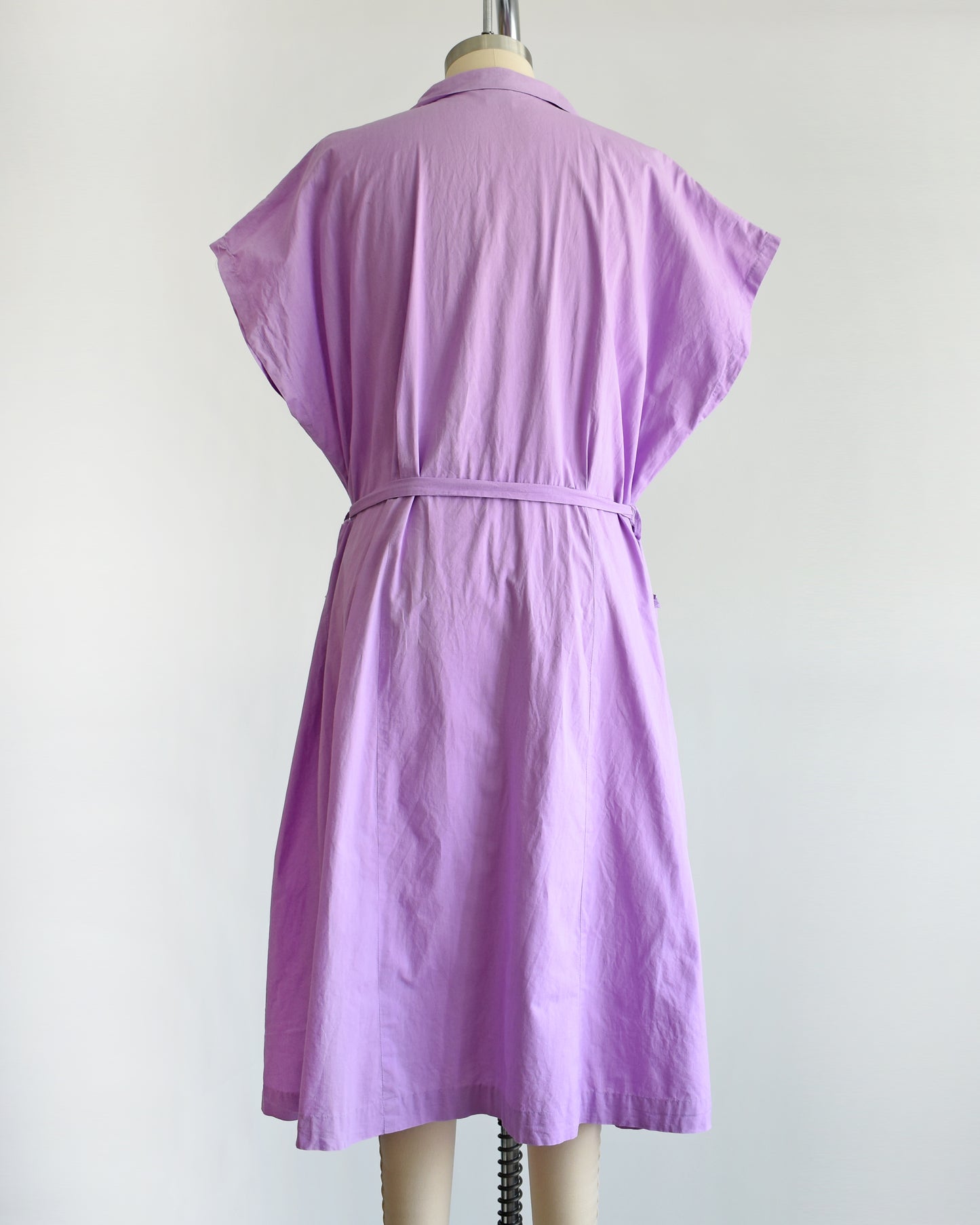 back view of a vintage 1950s purple dress by Fruit of the Loom on a mannequin against a white background
