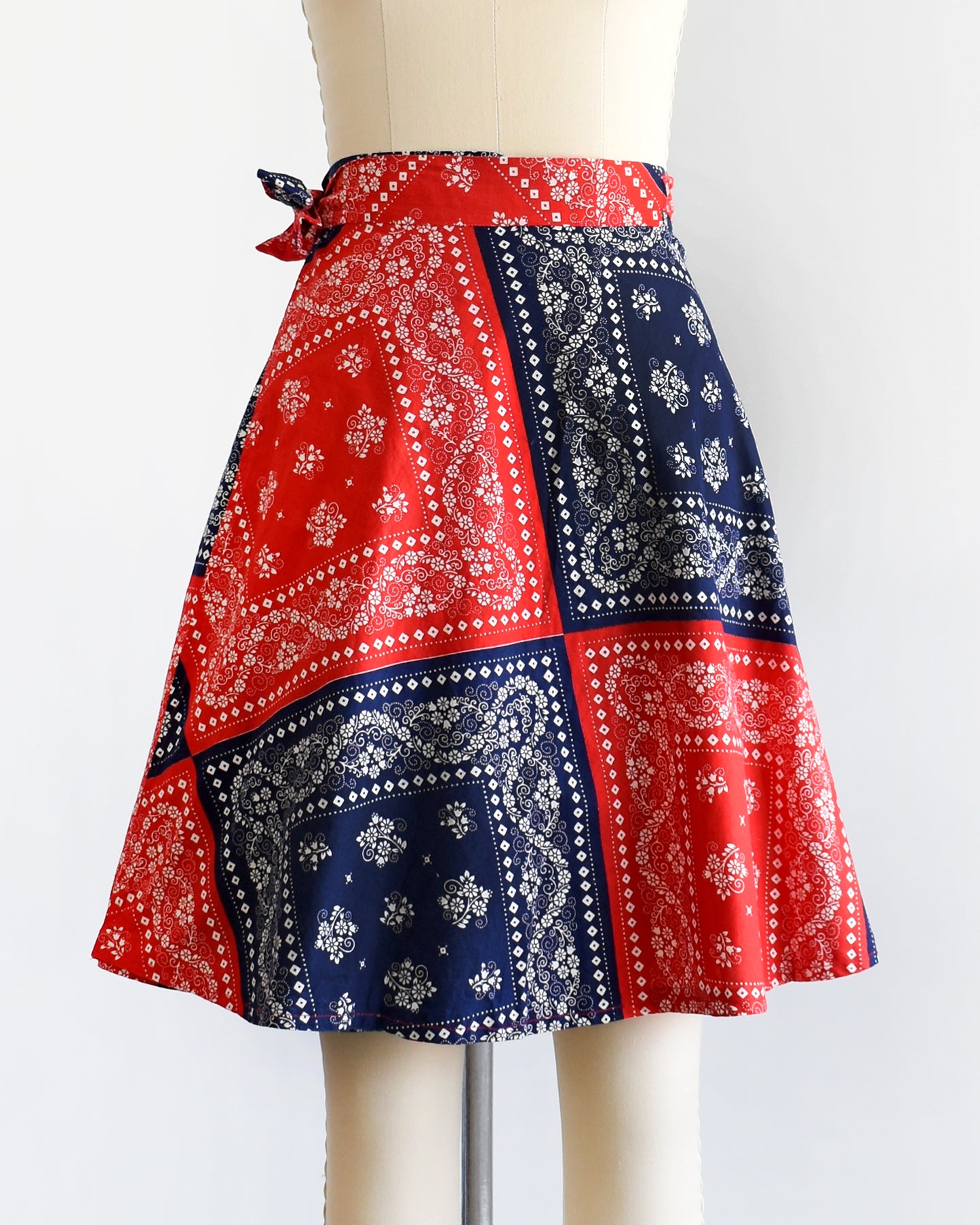 a vintage 1970s red and blue bandana patterned skirt on a mannequin against a white background