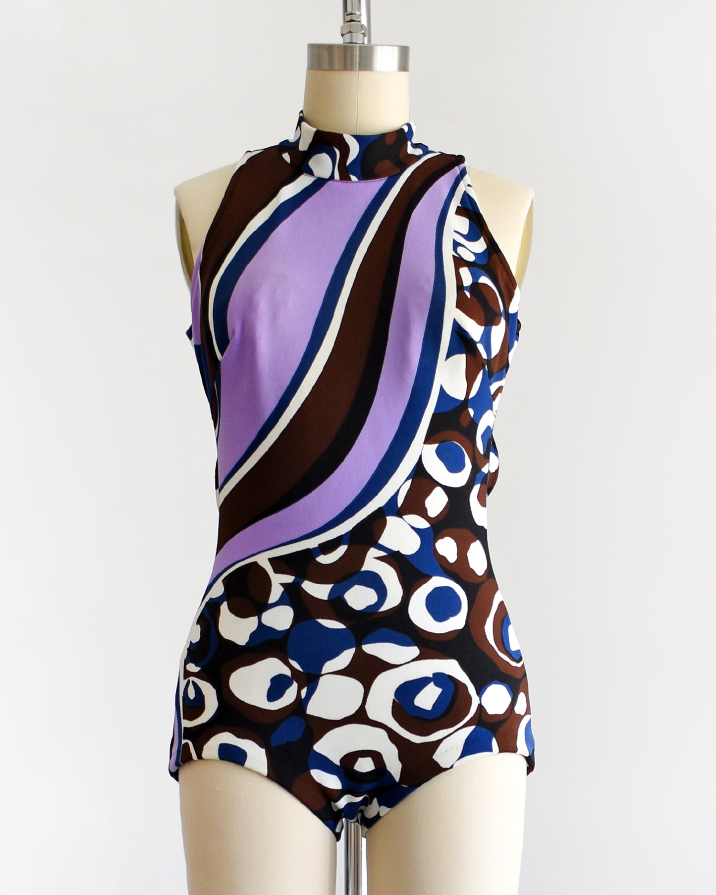 a vintage 1960s psychedelic swimsuit on a mannequin against a white background