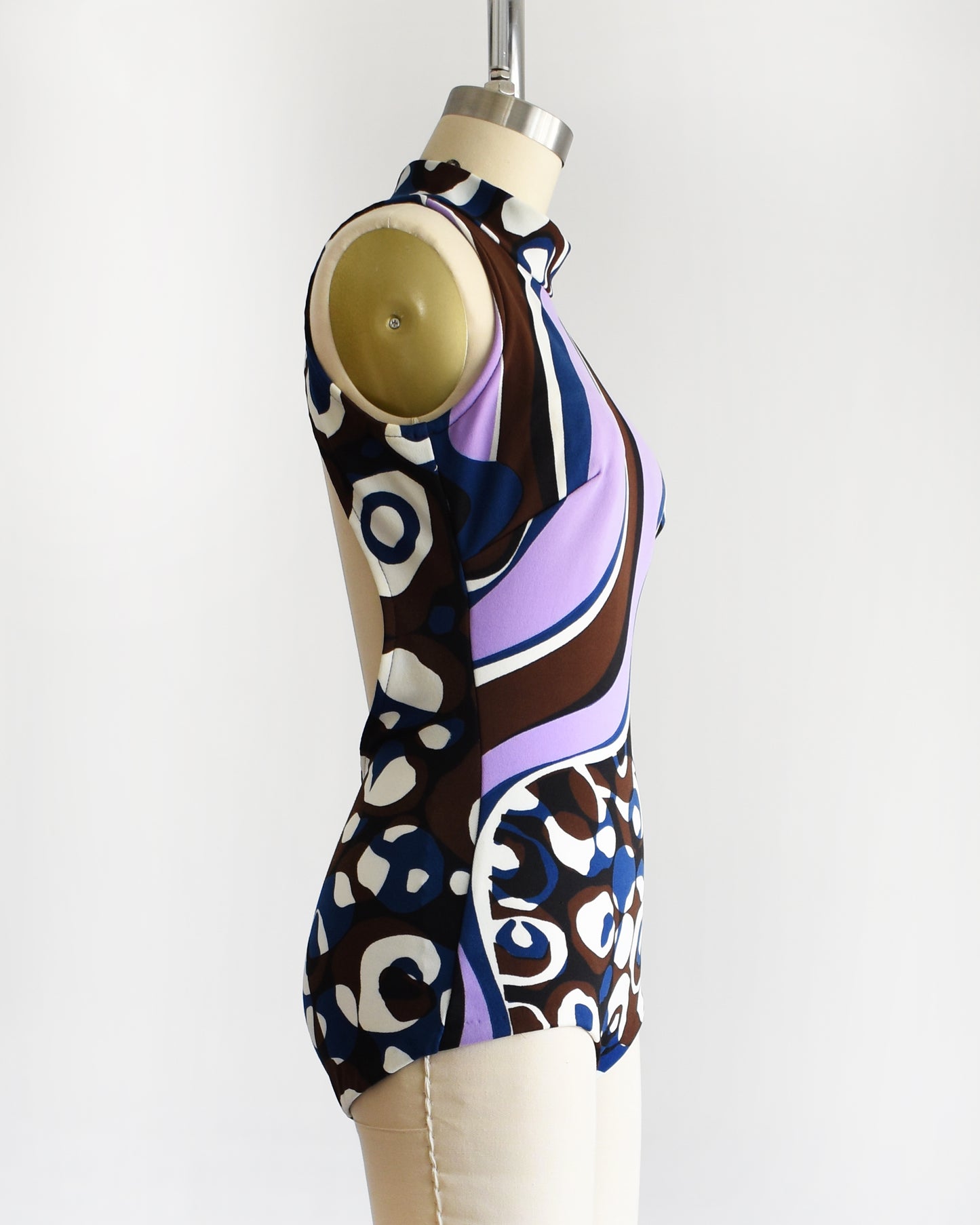 side view of a vintage 1960s psychedelic swimsuit on a mannequin against a white background