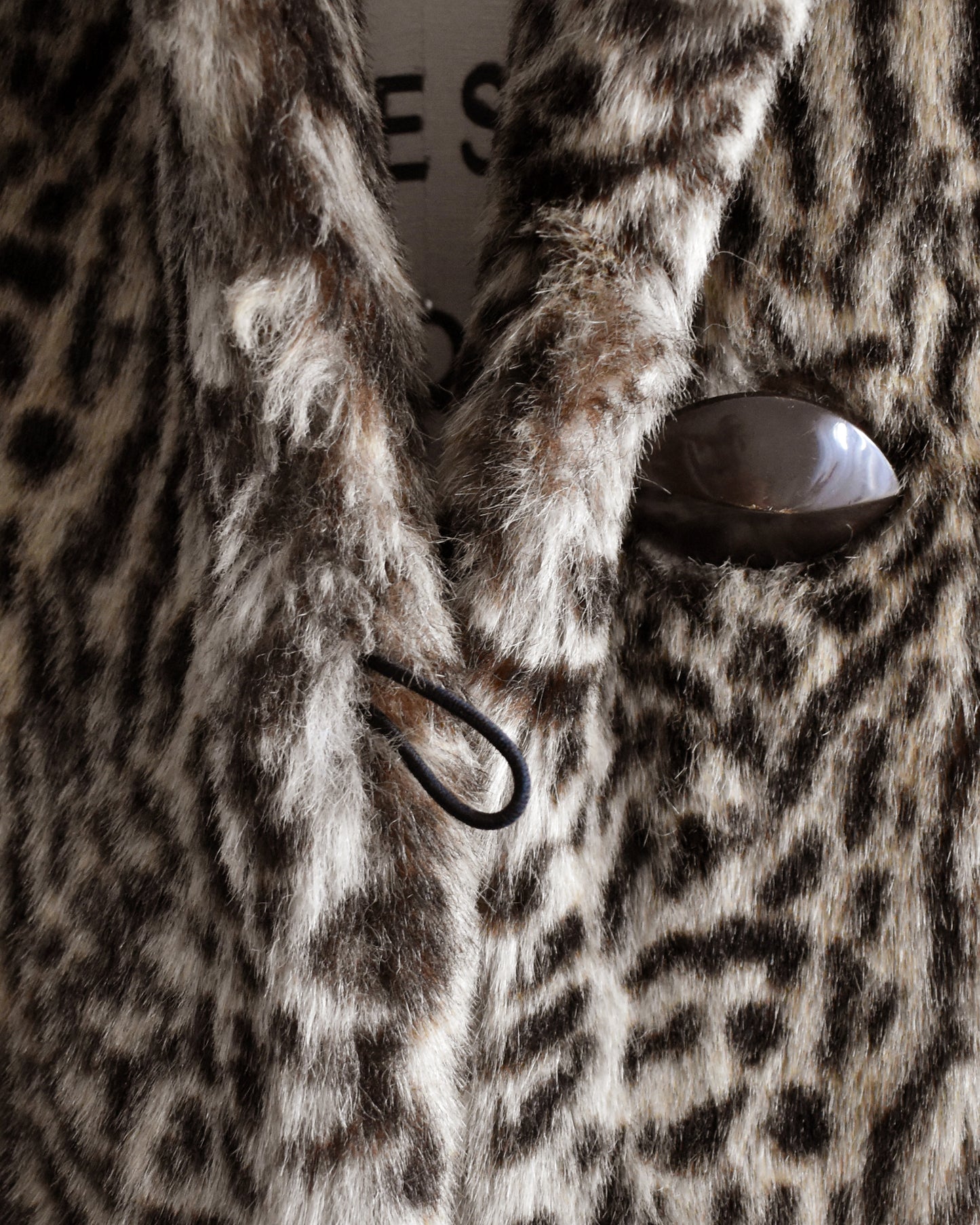 Close-up of a faux fur coat with a button and loop