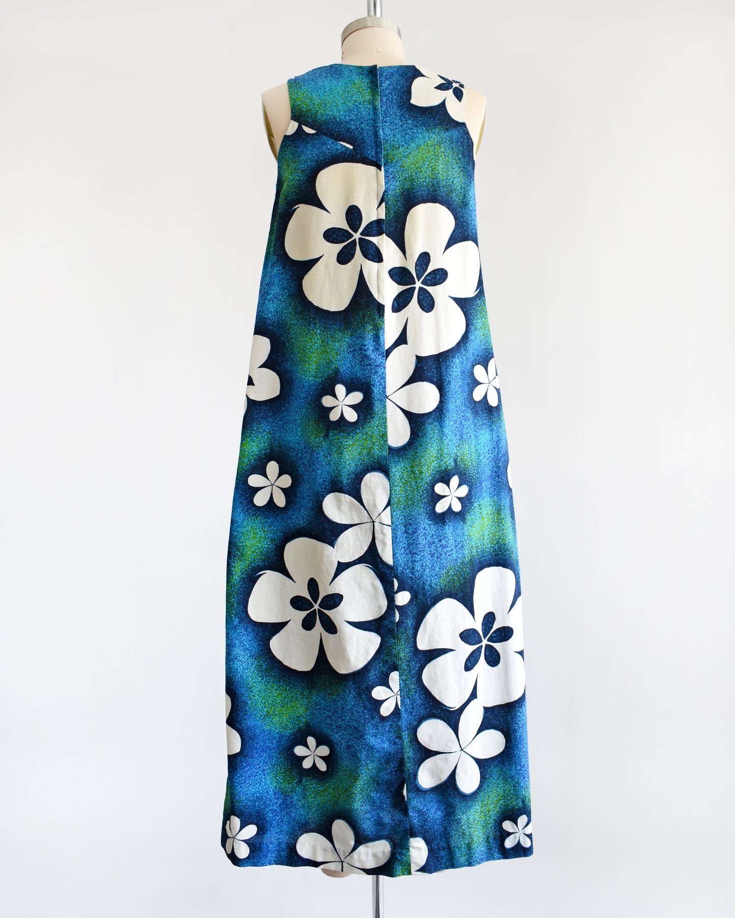 back view of a vintage 1970s blue and green Hawaiian maxi dress with white floral print