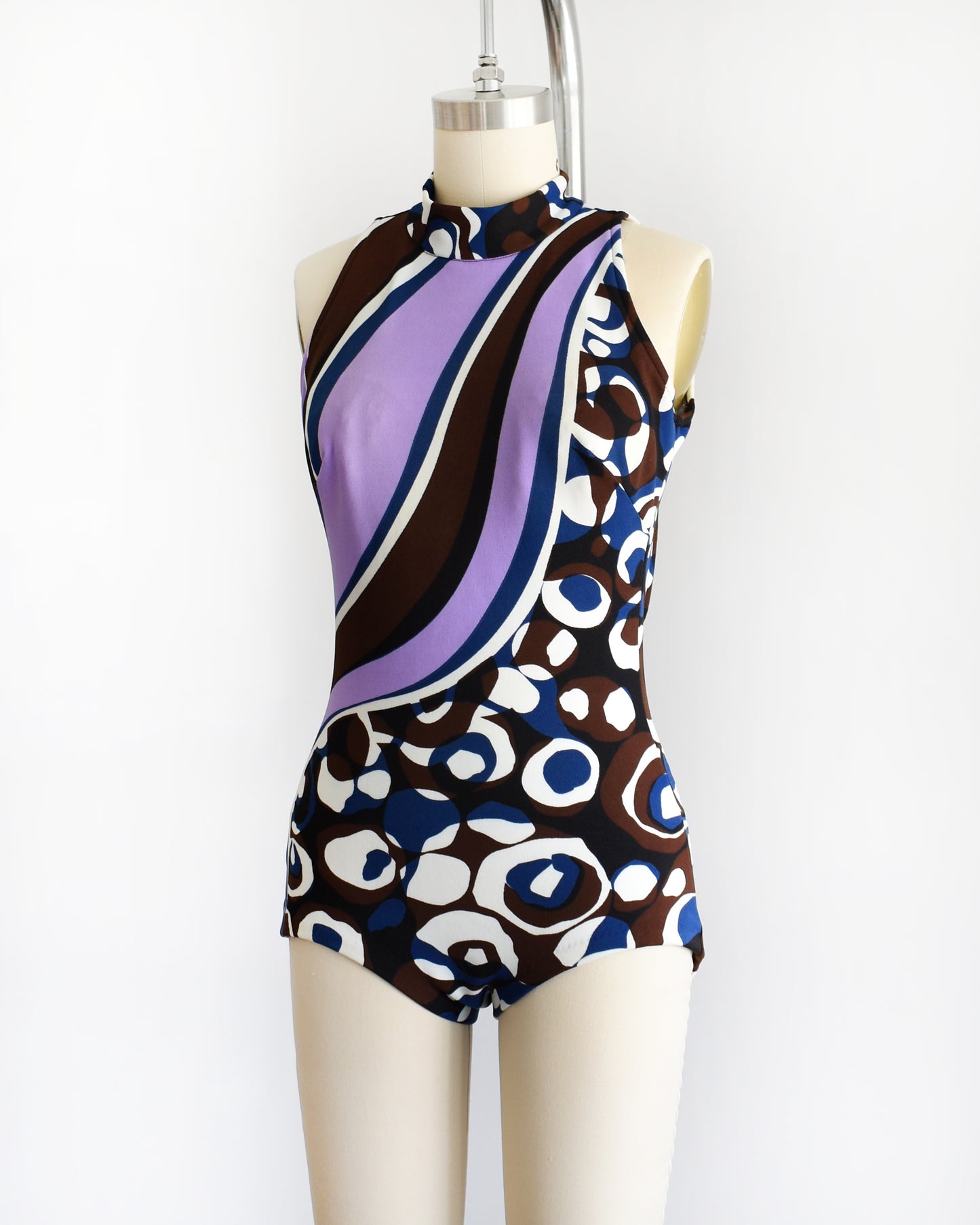 side front view of a vintage 1960s psychedelic swimsuit on a mannequin against a white background