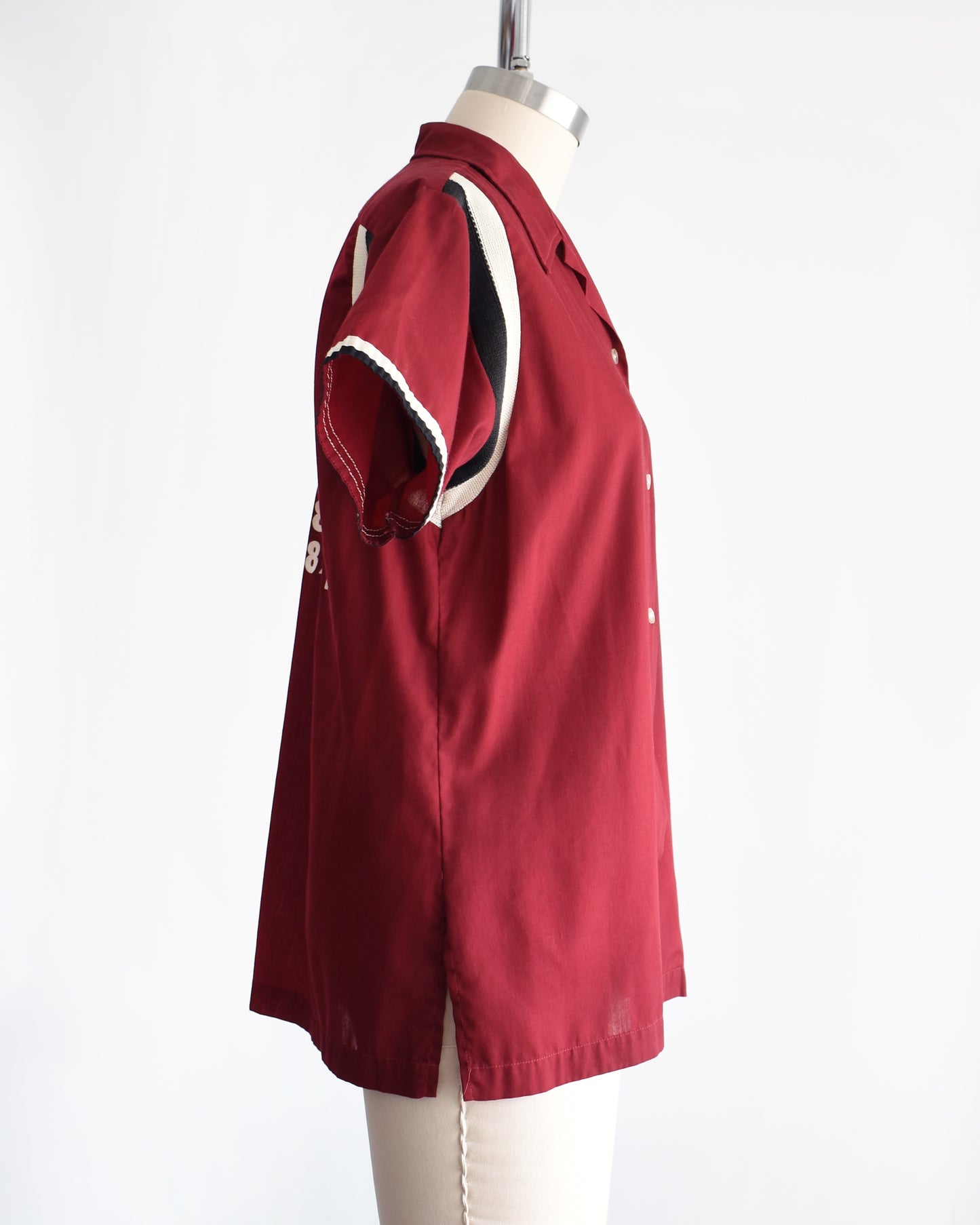 side view of a vintage 1960s Hilton bowling shirt with white text on a mannequin against a white background