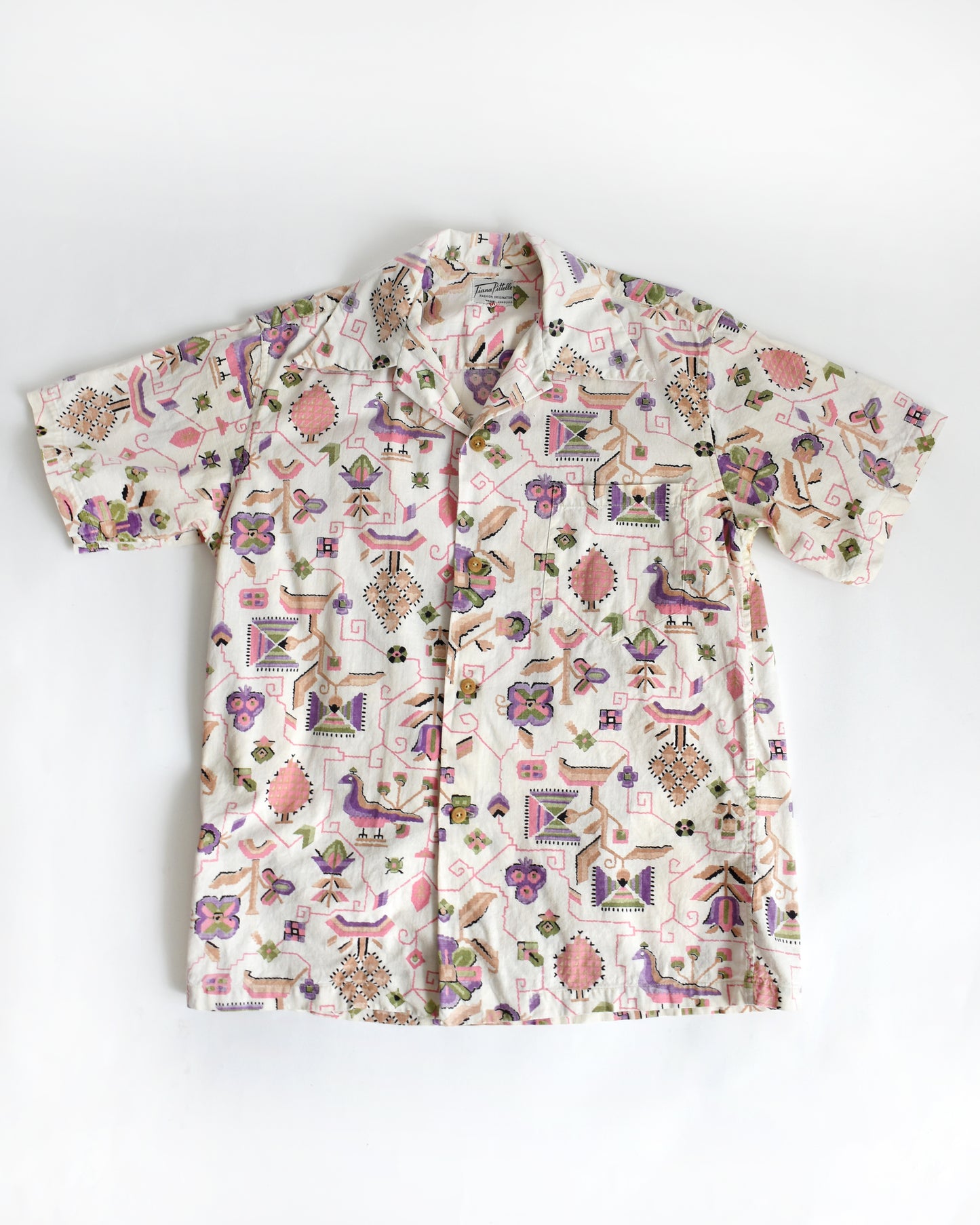a vintage 1950s Tiana Pittelle short-sleeve Hawaiian aloha shirt with a colorful pattern on a white background