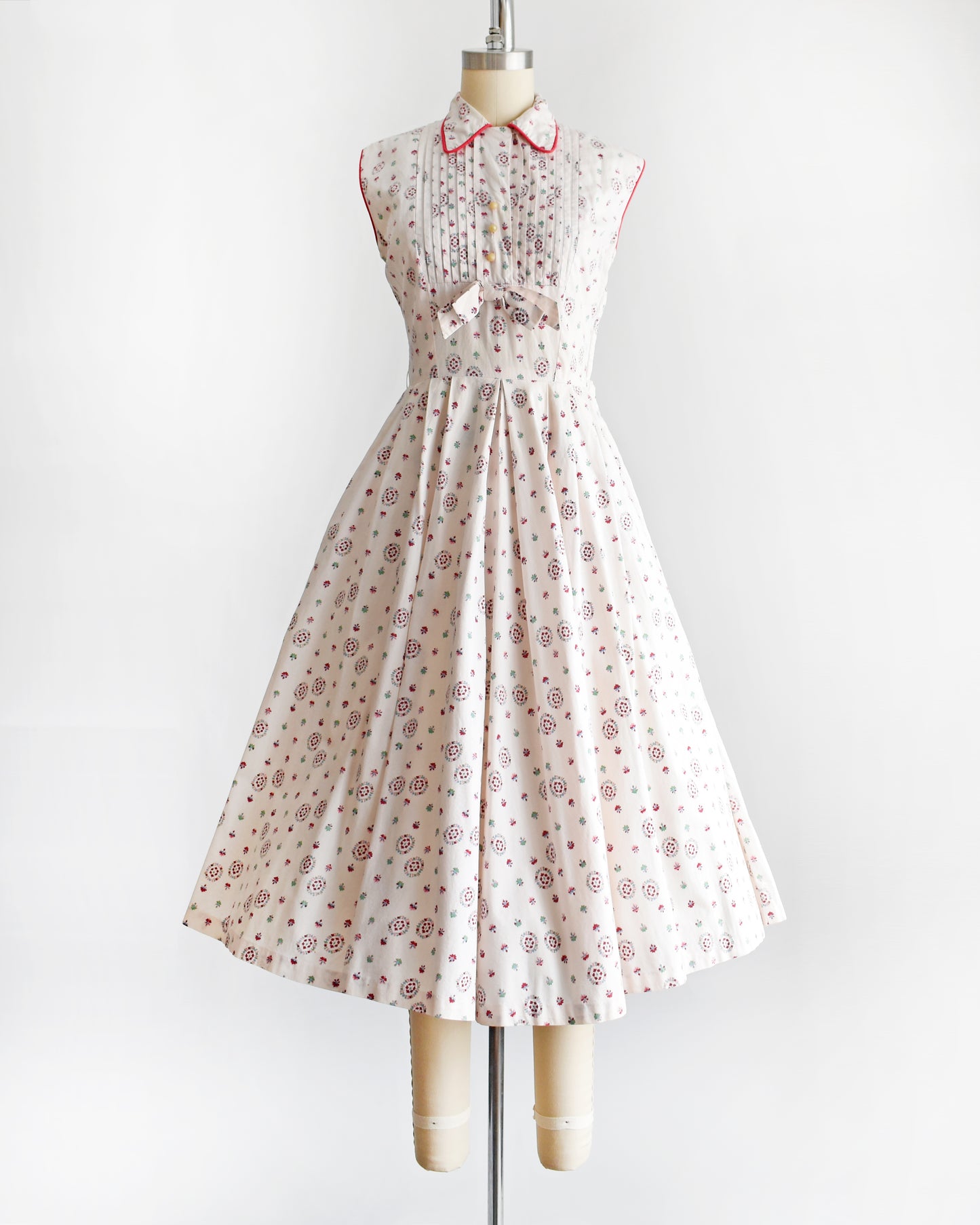 a vintage 1950s floral dress on a mannequin against a white background