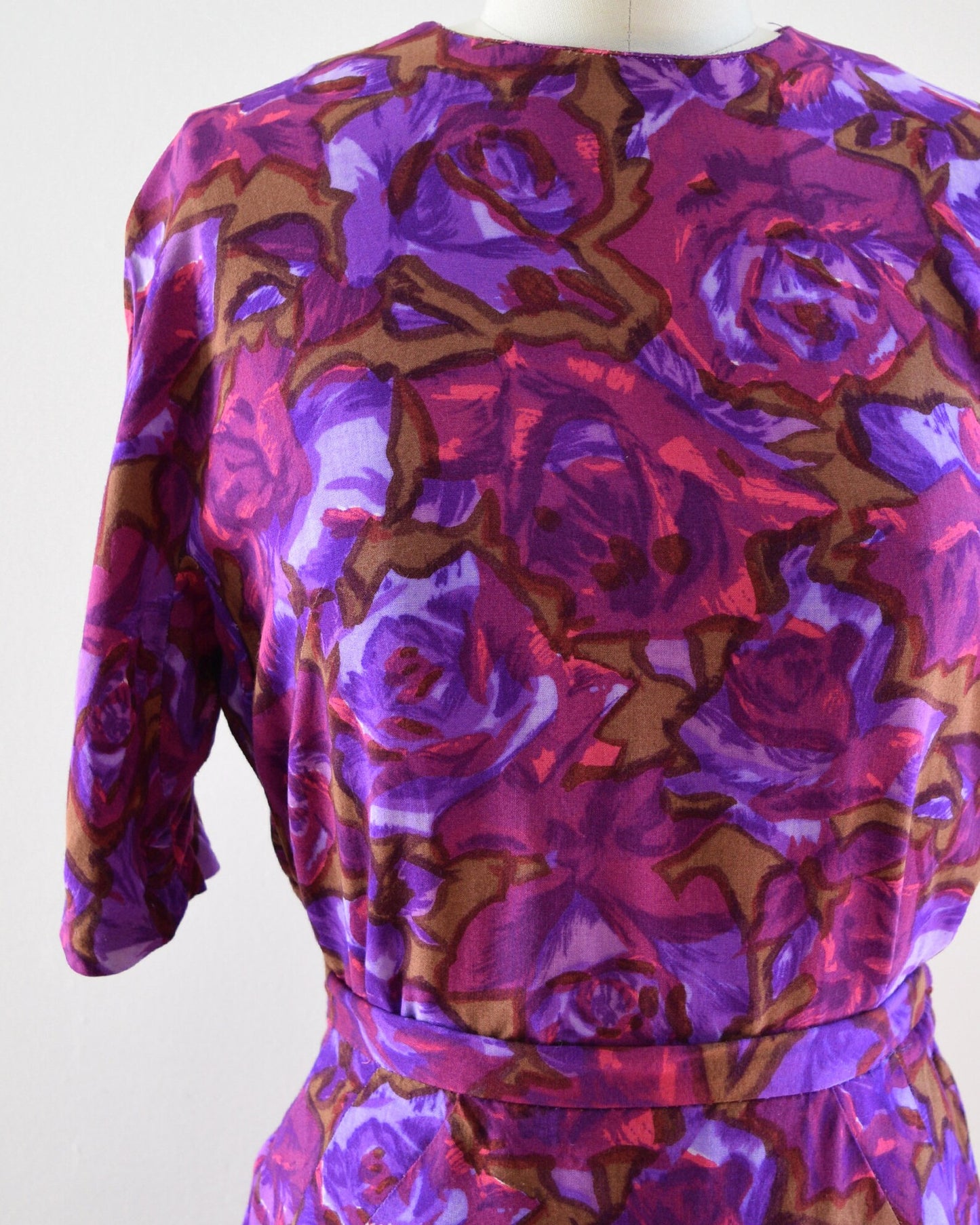 Close up of the various shades of purple, along with bright pink, and light brown mid century floral print.