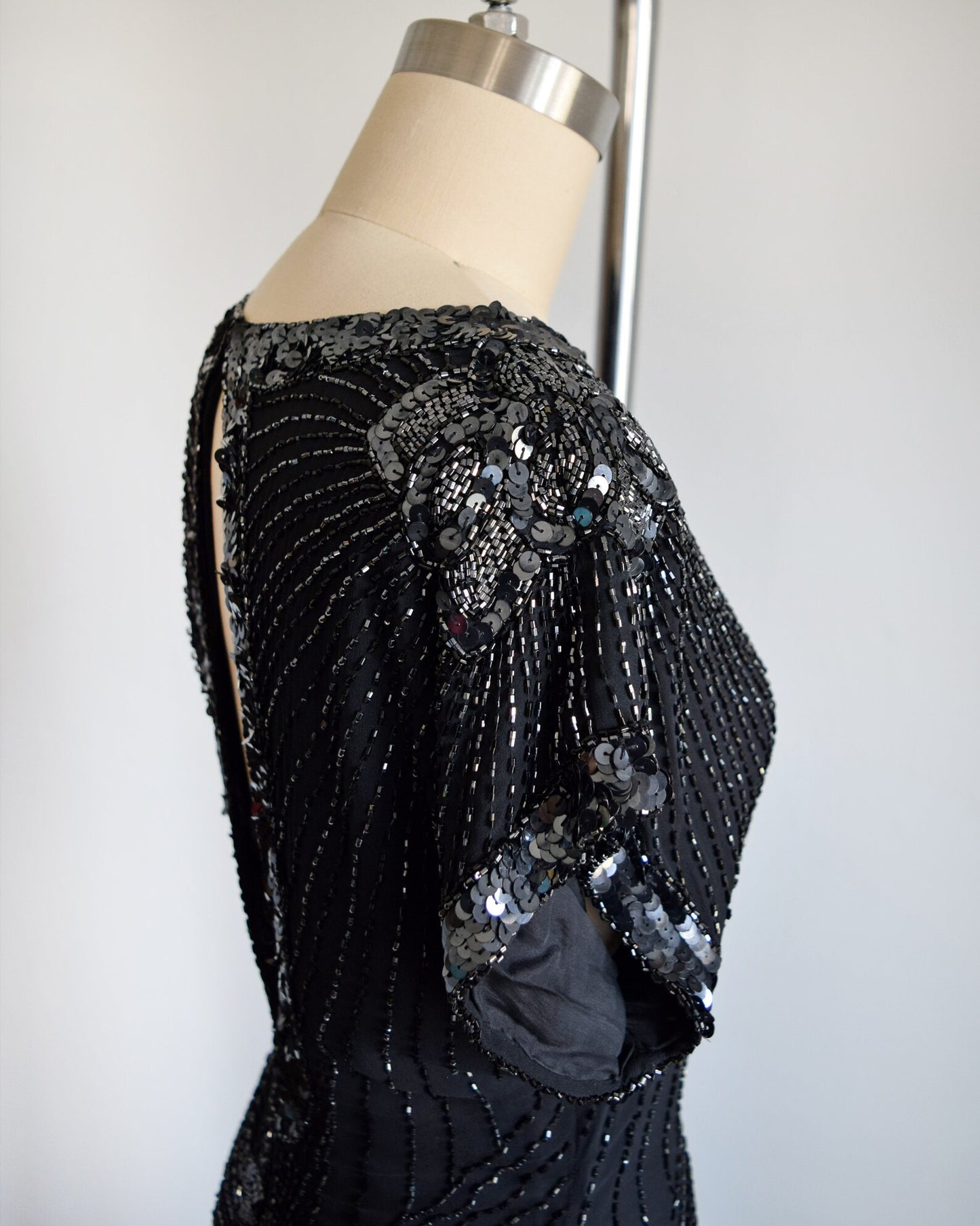 Side view of the shoulder and short sleeve which is adorned with sequins and beads